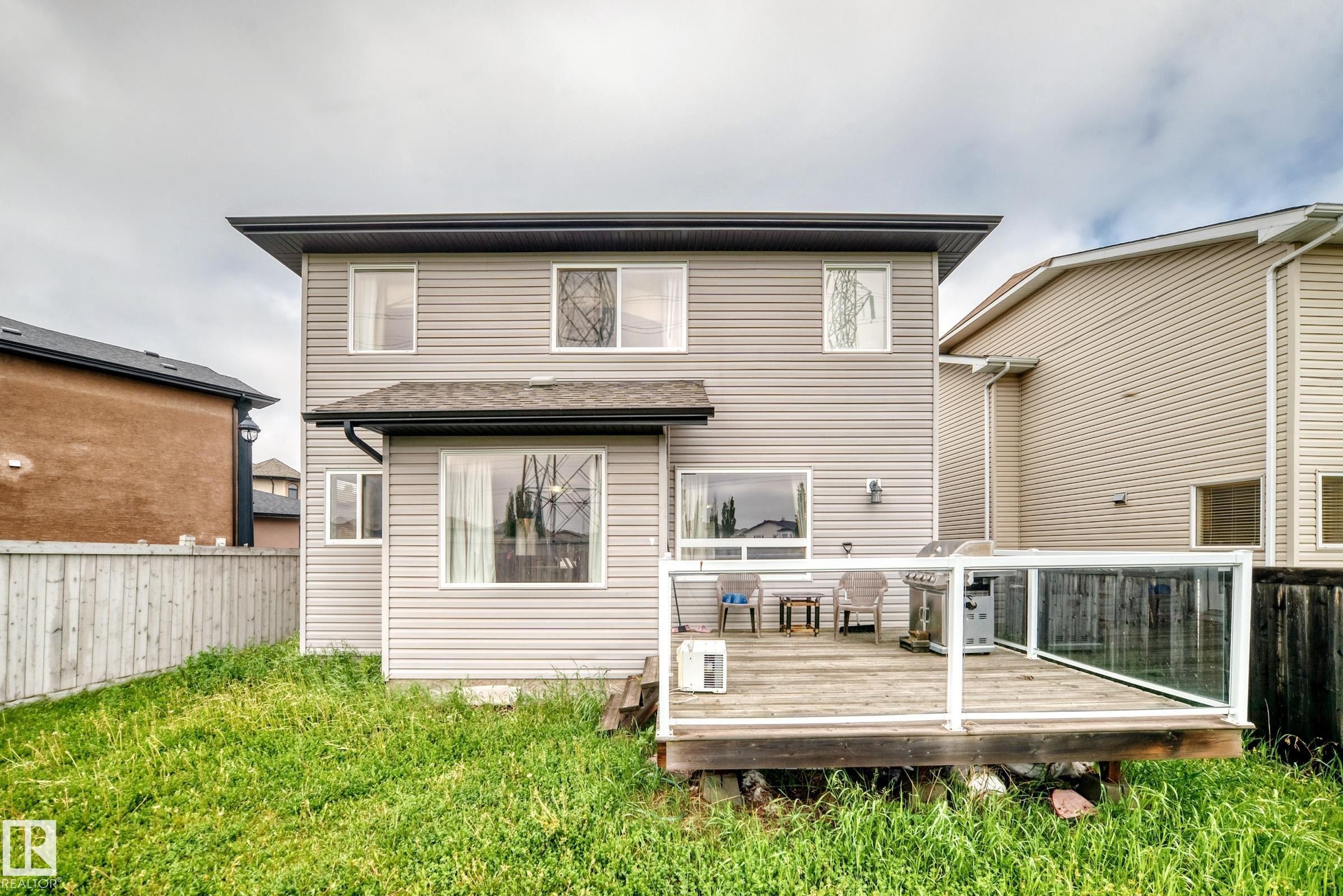 Rear exterior featuring light-toned horizontal siding and a dark shingled roof - 2808 36 Avenue, Edmonton, AB