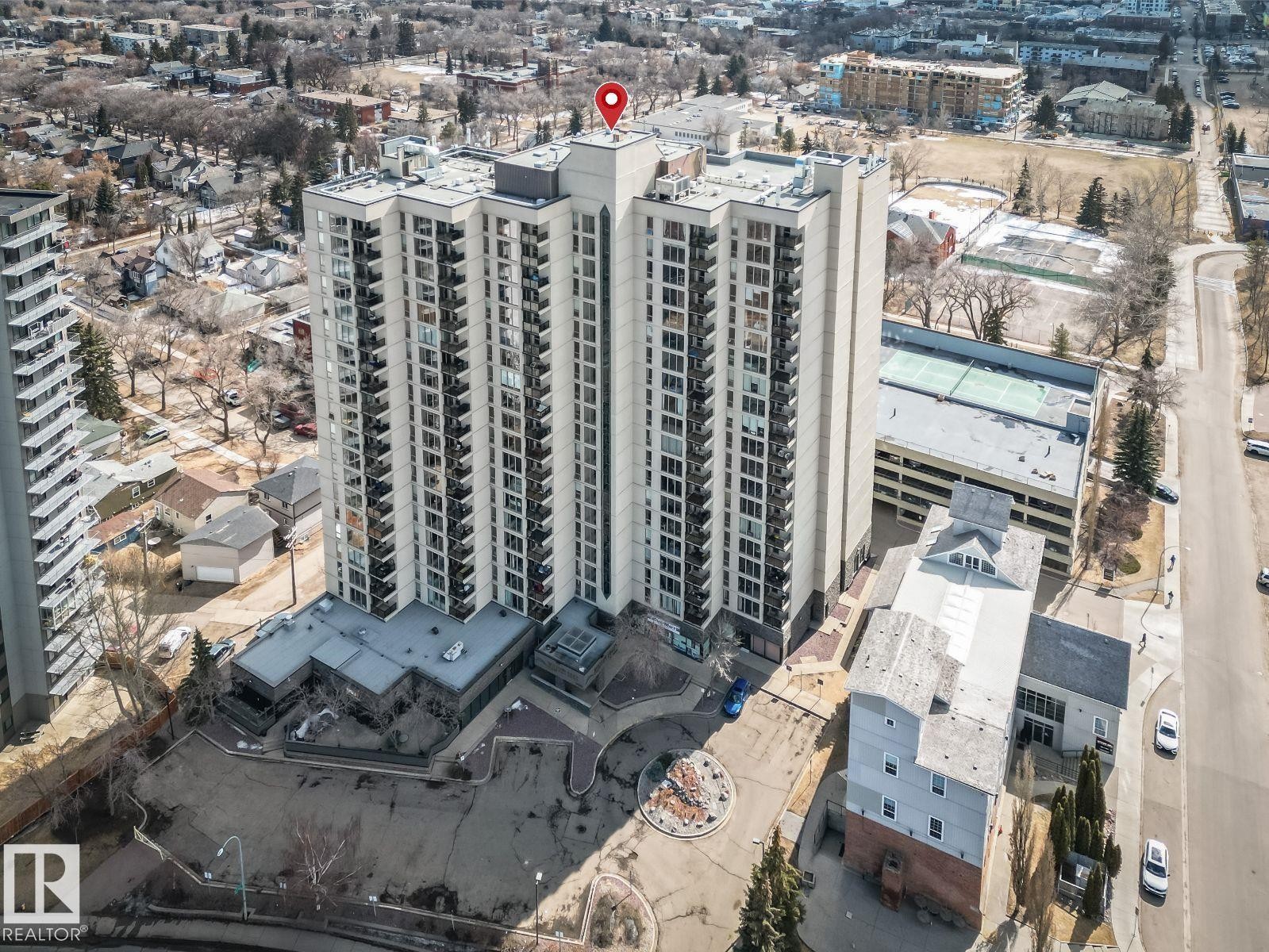 High-rise residential building featuring multiple balconies, a structured parking garage, and a tennis court on its rooftop - 806 10149 Saskatchewan Drive, Edmonton, AB