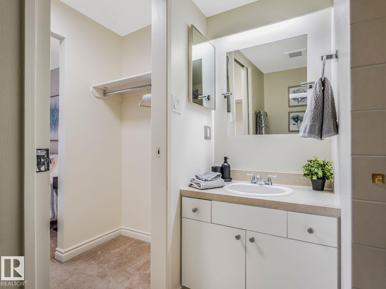 Vanity with an integrated sink, light-toned countertop, and white cabinetry - 806 10149 Saskatchewan Drive, Edmonton, AB