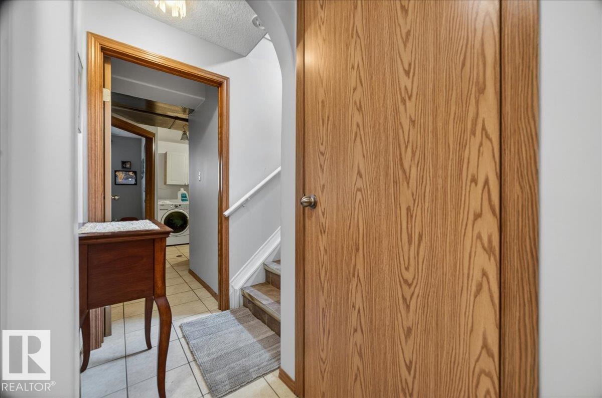 Panel door with a wood-grain finish and a polished chrome knob - 5108 138A Avenue, Edmonton, AB