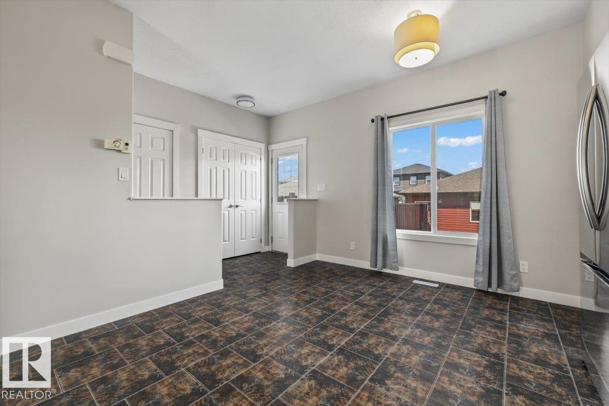 Spacious room with dark-toned tile flooring, light grey painted walls, and white trim - 356 Pioneer Road, Spruce Grove, AB