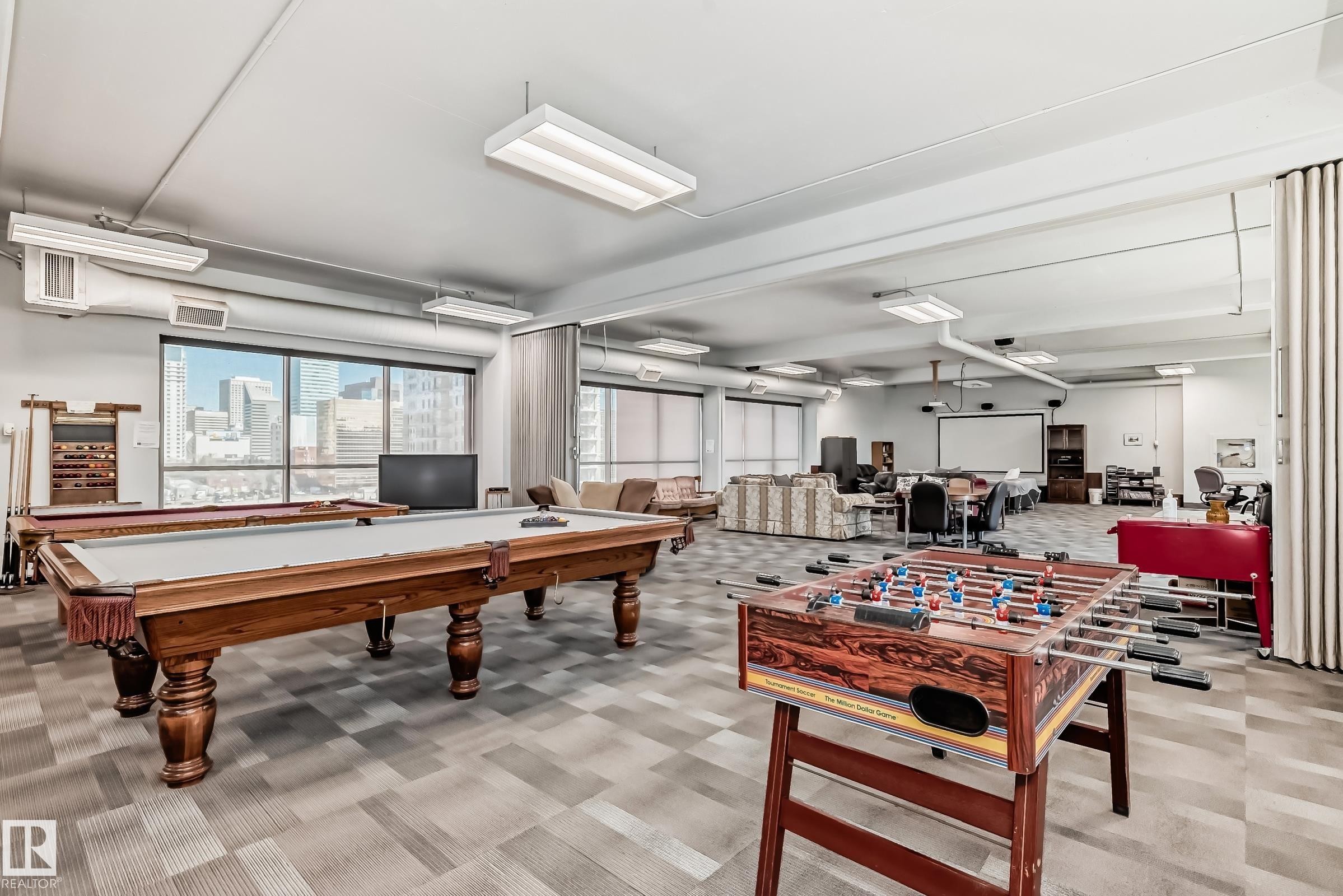 Spacious recreation room featuring two billiards tables and foosball - #706 10125 109 St Nw, Edmonton, AB