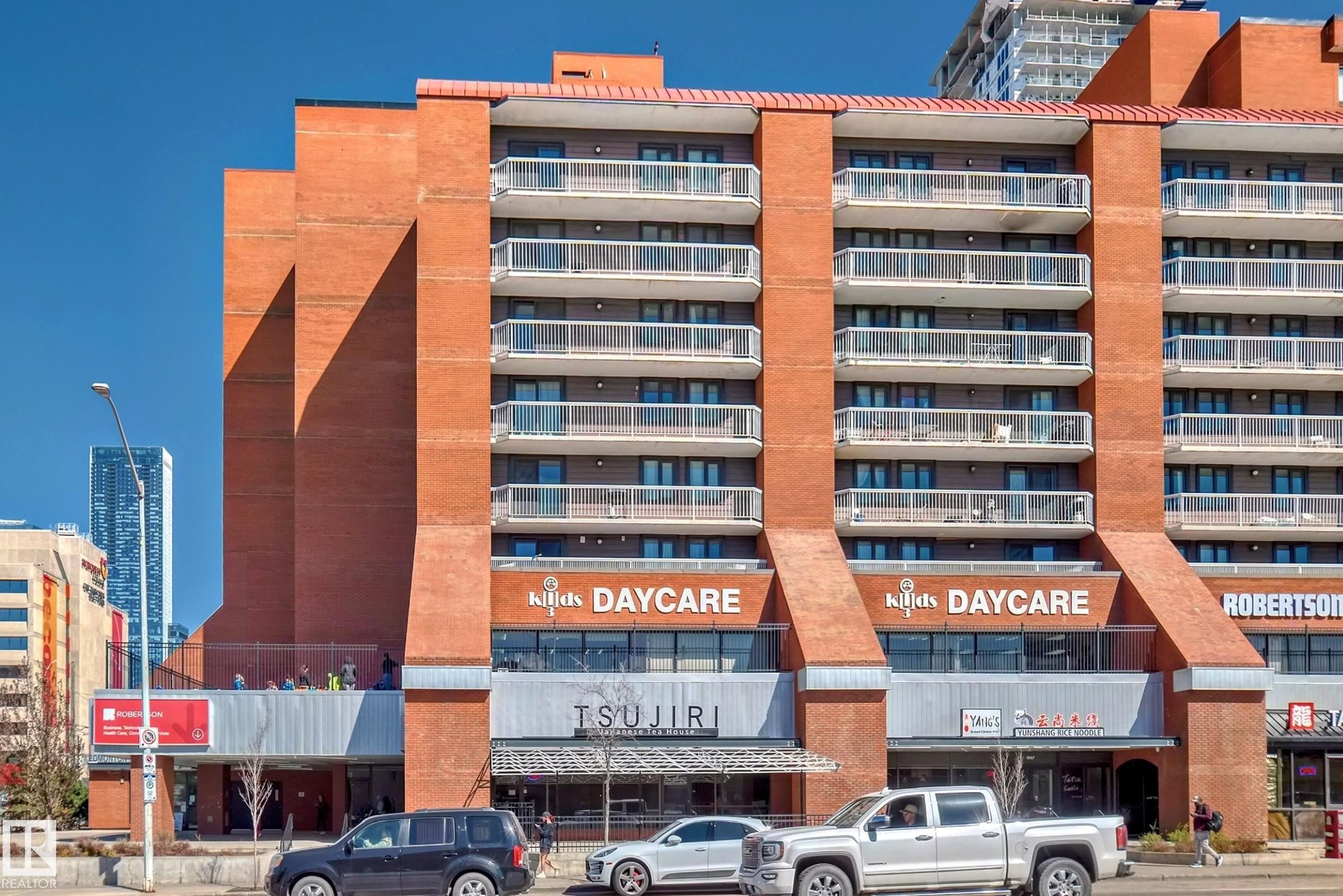 Multi-story brick building featuring multiple private balconies with glass railings - #706 10125 109 St Nw, Edmonton, AB