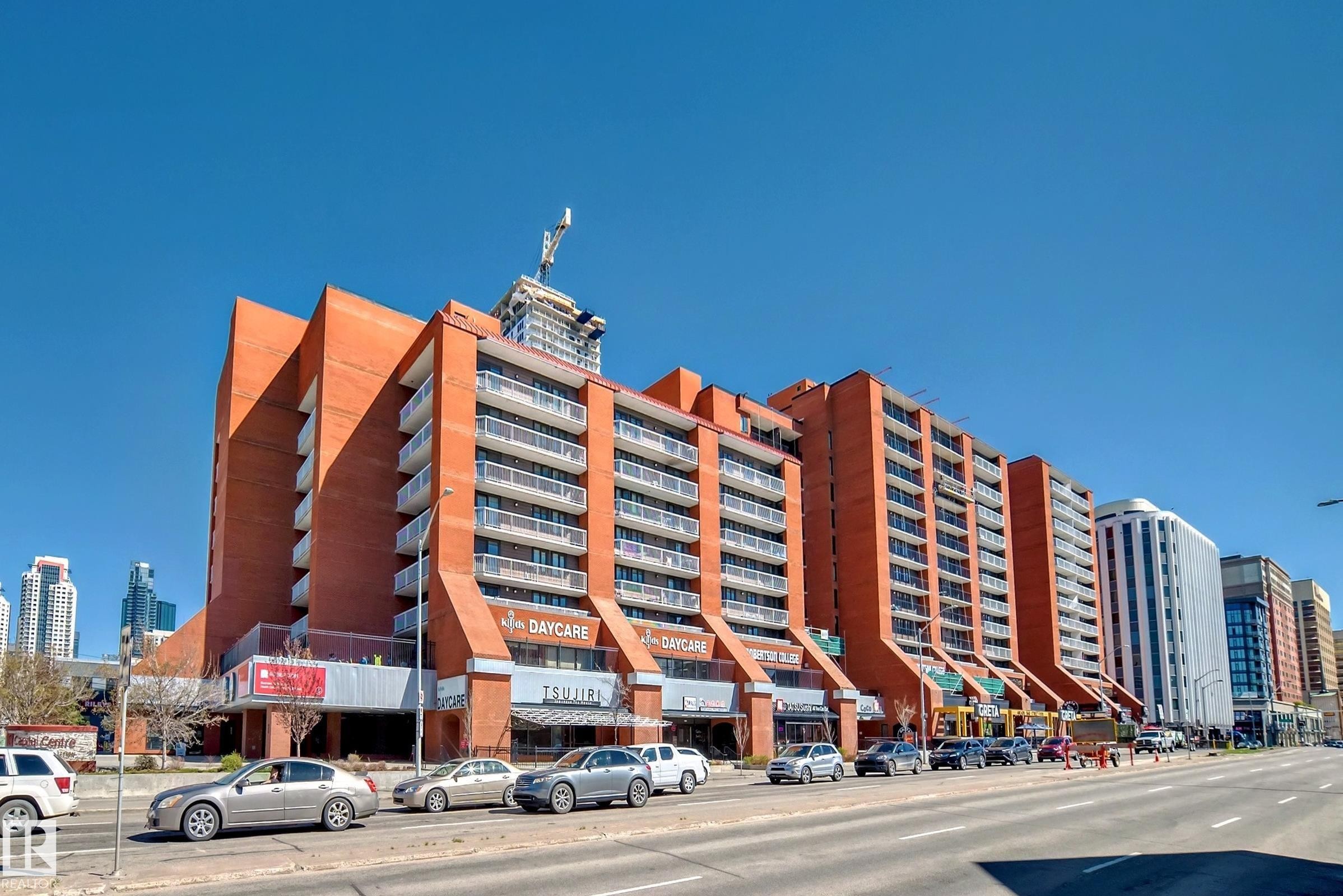 Multi-story building featuring a prominent brick exterior and multiple private balconies - #706 10125 109 St Nw, Edmonton, AB