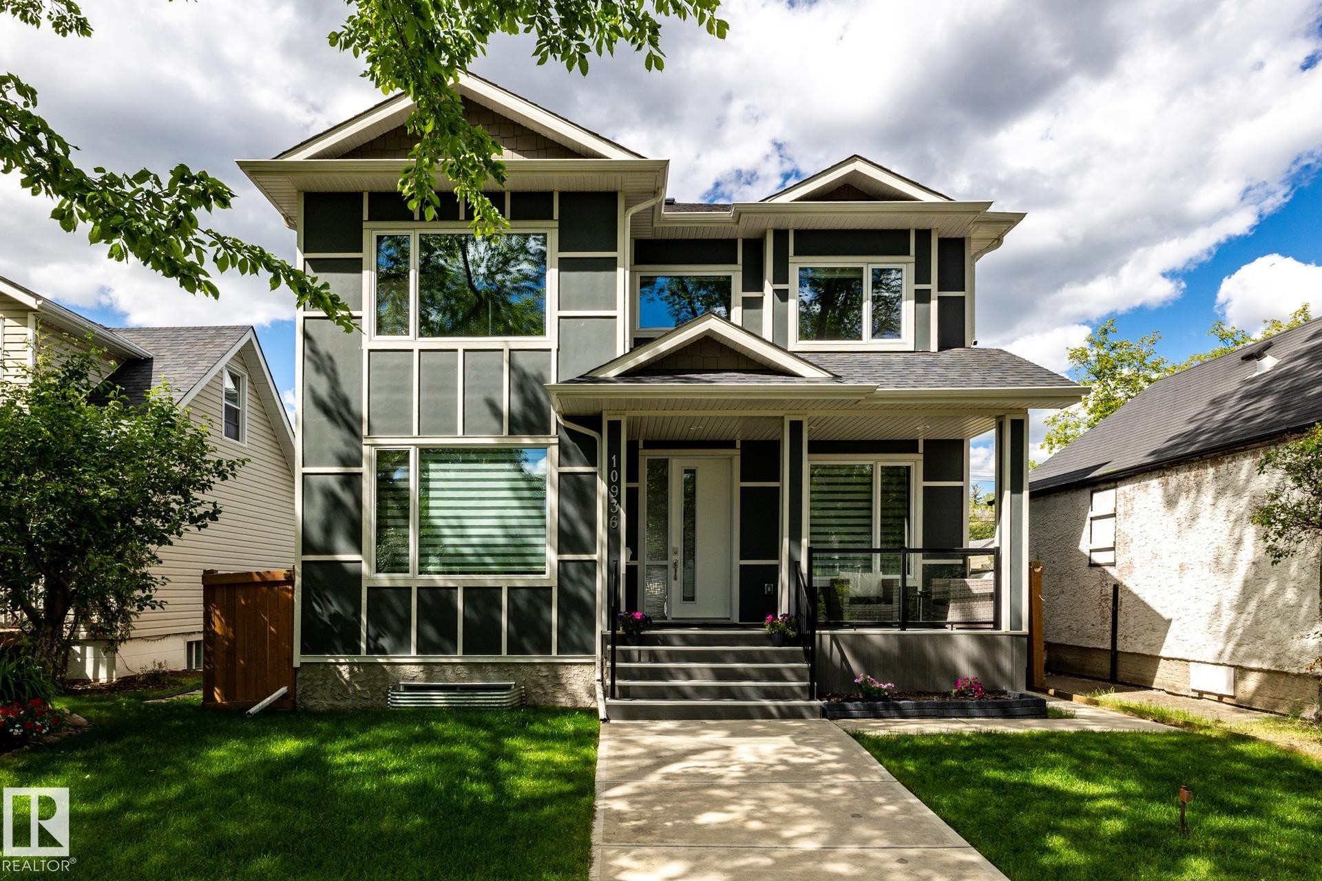Contemporary two-story residence featuring dark gray siding with white trim accents and a gabled roofline - 10936 71 Avenue, Edmonton, AB