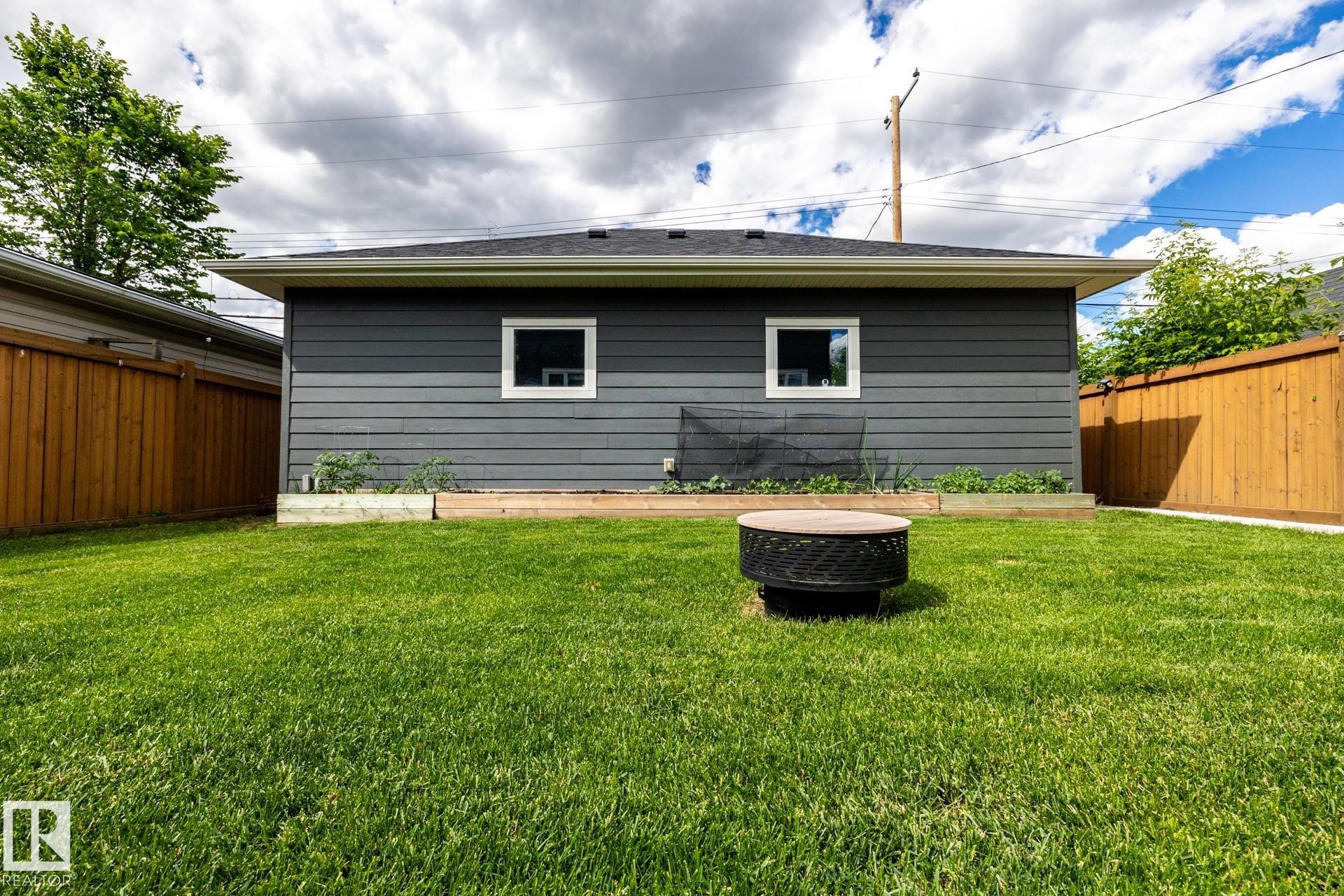 Expansive green lawn with a round fire pit - 10936 71 Avenue, Edmonton, AB