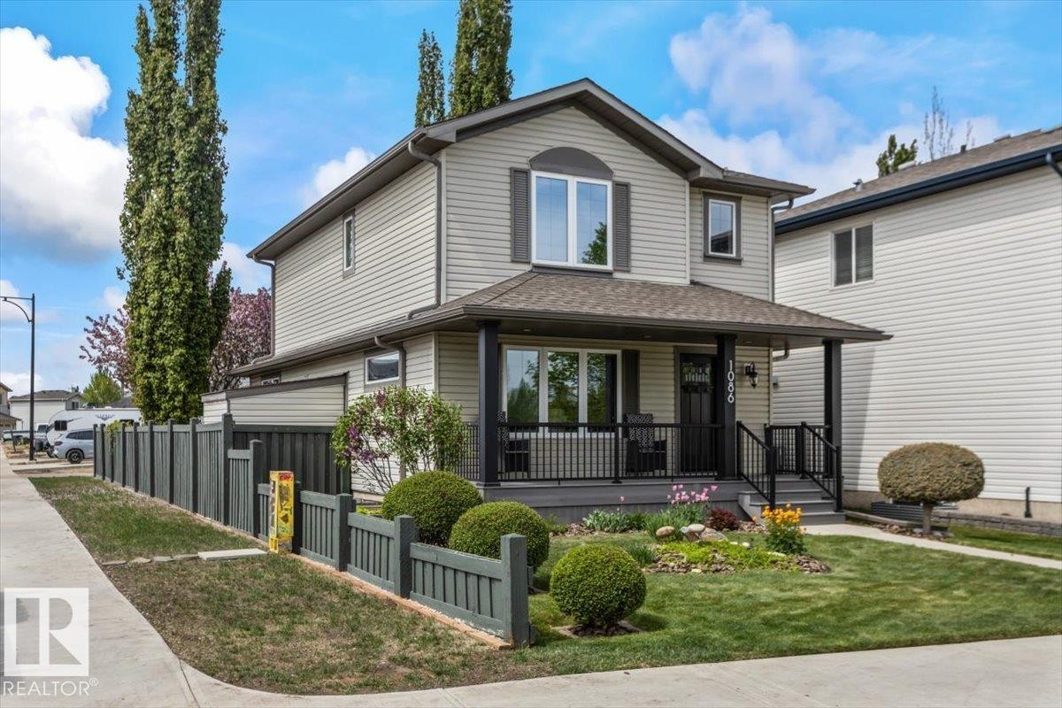 Two-story residence featuring light-toned siding and dark trim accents - 1086 Grantham Drive Nw, Edmonton, AB - Outdoor With Deck Patio Veranda