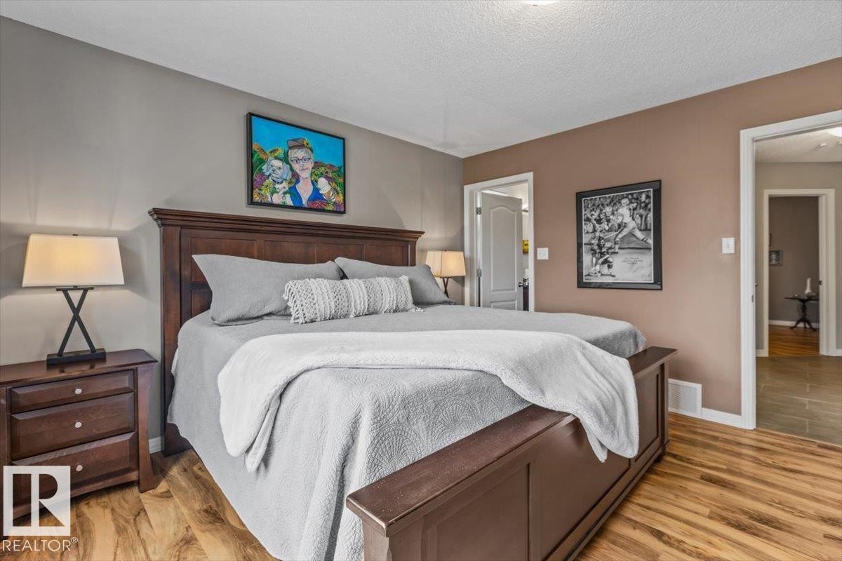 Spacious room featuring wood-finish flooring, two-tone painted walls, and white trim - 1086 Grantham Drive Nw, Edmonton, AB - Indoor Photo Showing Bedroom