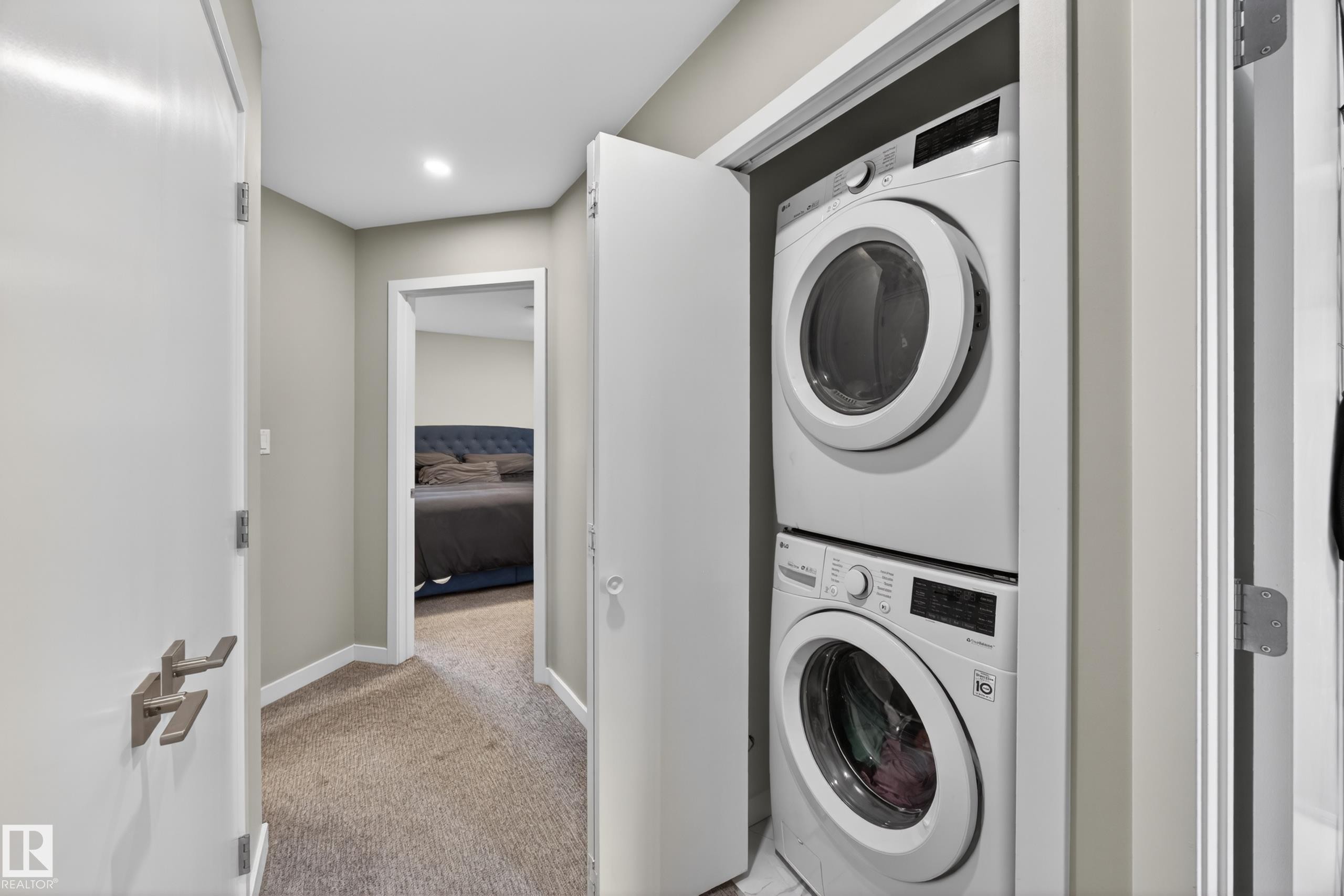 Integrated laundry closet featuring a stacked washer and dryer - 12604 116 Avenue, Edmonton, AB