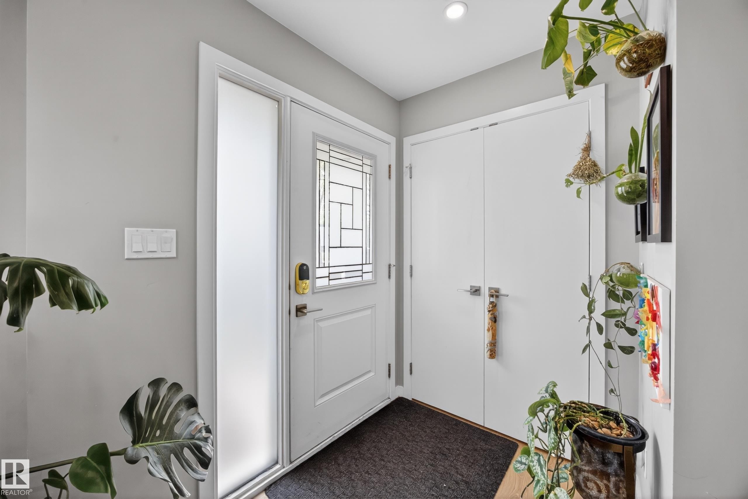 Entryway featuring a white door with decorative glass inserts, frosted sidelight, and a digital keypad - 12604 116 Avenue, Edmonton, AB