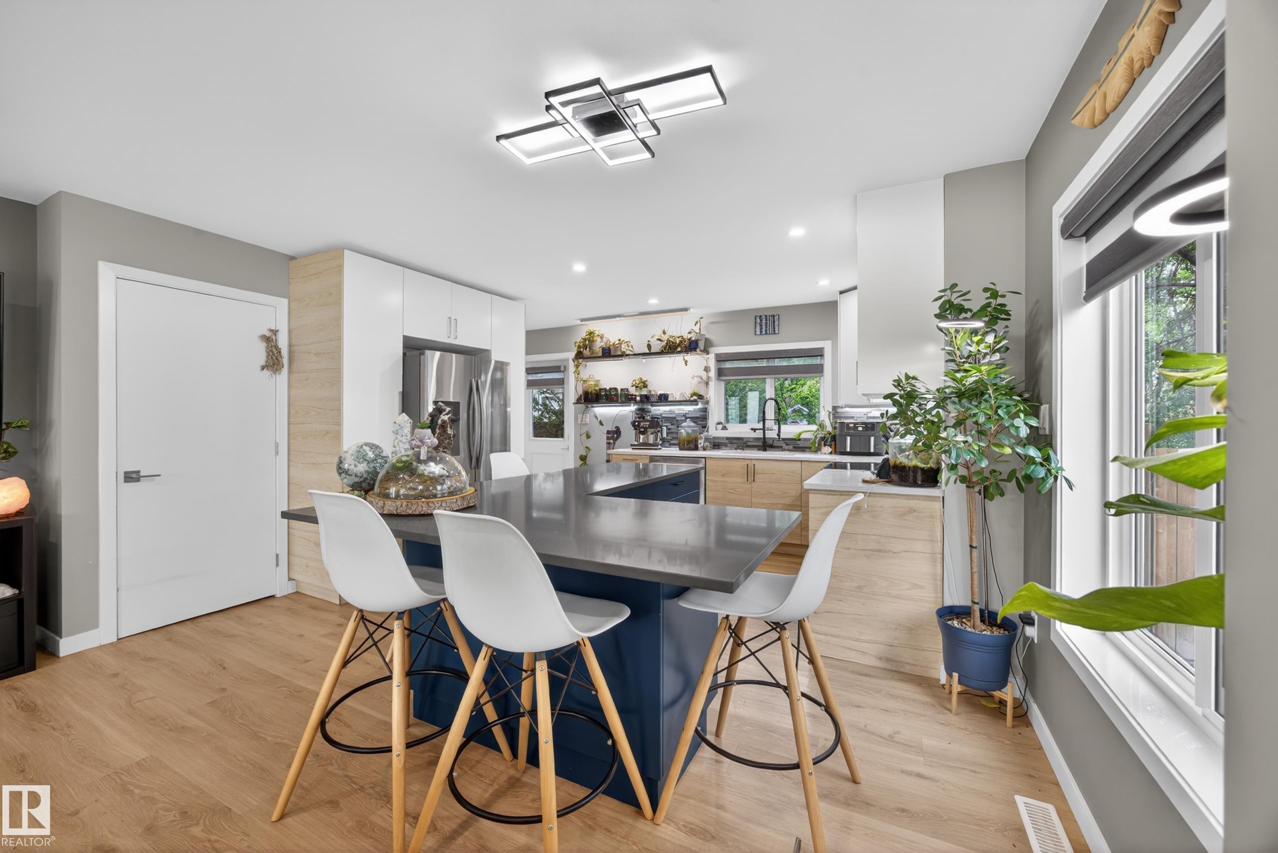 Kitchen with a large island featuring a dark countertop and blue base cabinetry - 12604 116 Avenue, Edmonton, AB