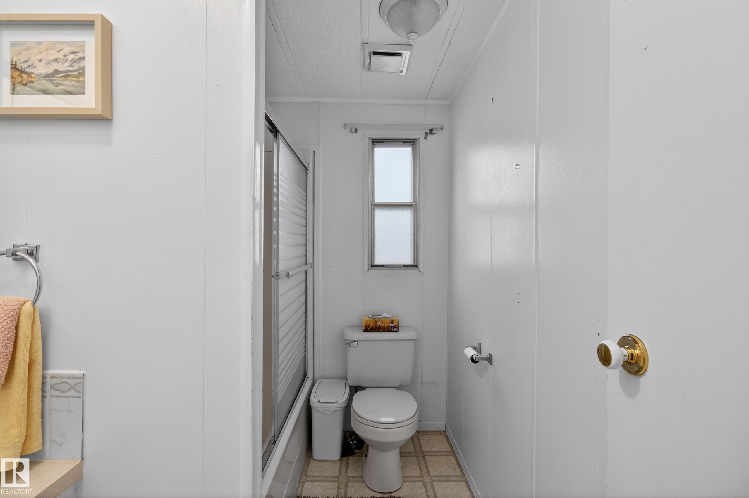 Bathroom featuring a white toilet, frosted window, sliding glass shower enclosure, and tiled flooring - 21 Willowdale Drive, Edmonton, AB - Indoor Photo Showing Bathroom