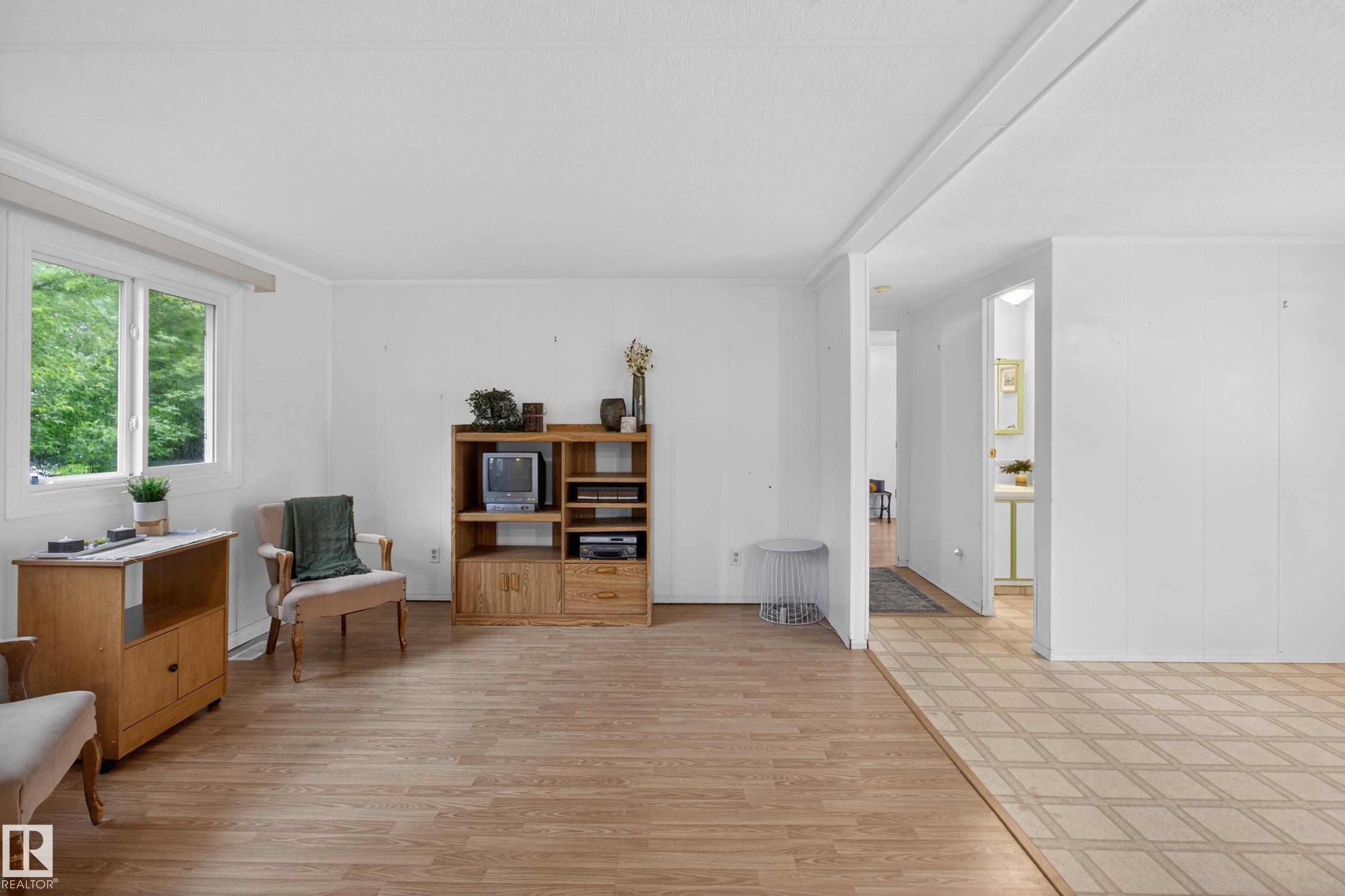 Living area with wood-finish flooring, white walls, and a large window - 21 Willowdale Drive, Edmonton, AB - Indoor