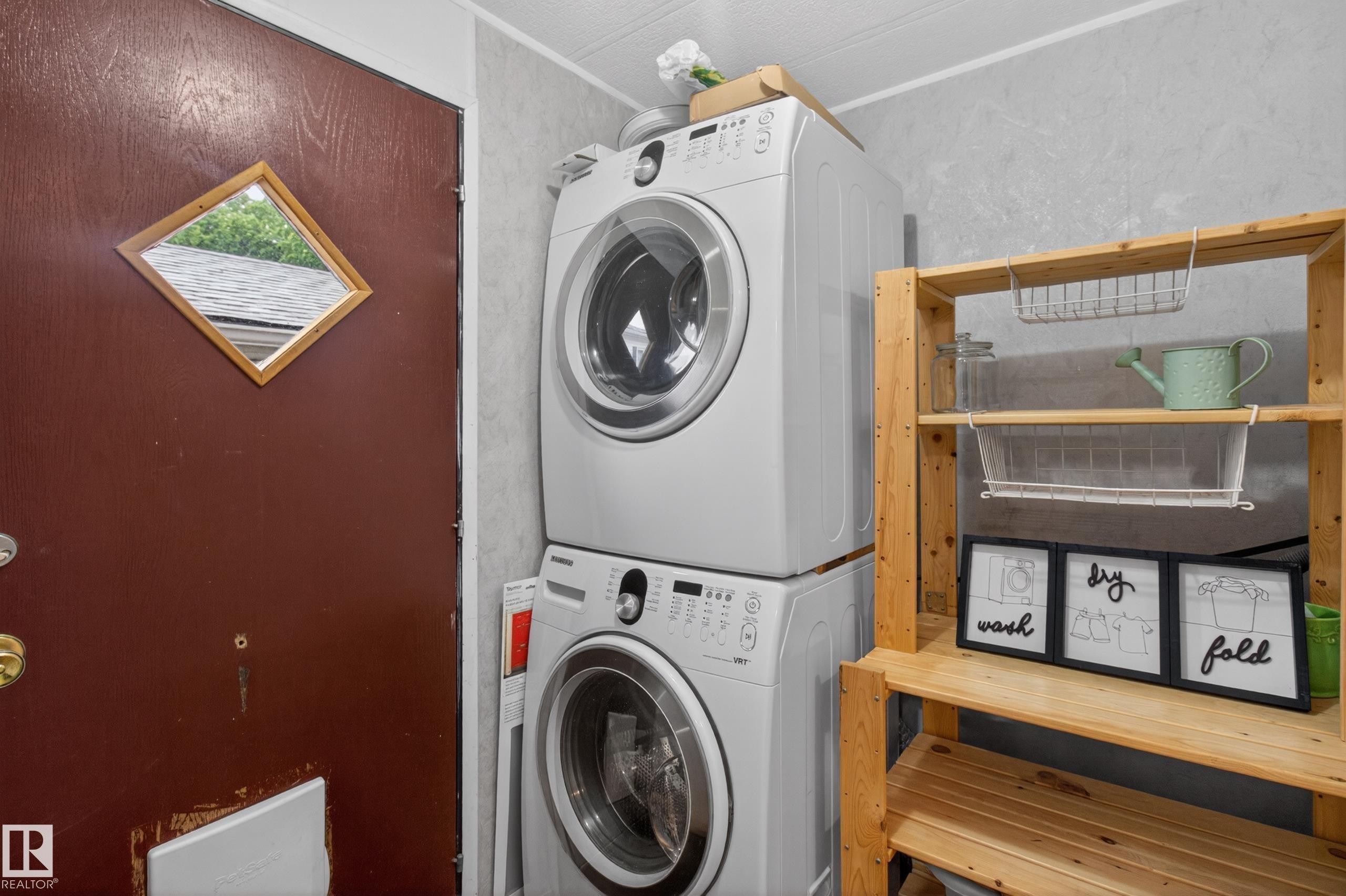 Dedicated laundry area featuring stacked front-loading washer and dryer units - 21 Willowdale Drive, Edmonton, AB - Indoor Photo Showing Laundry Room