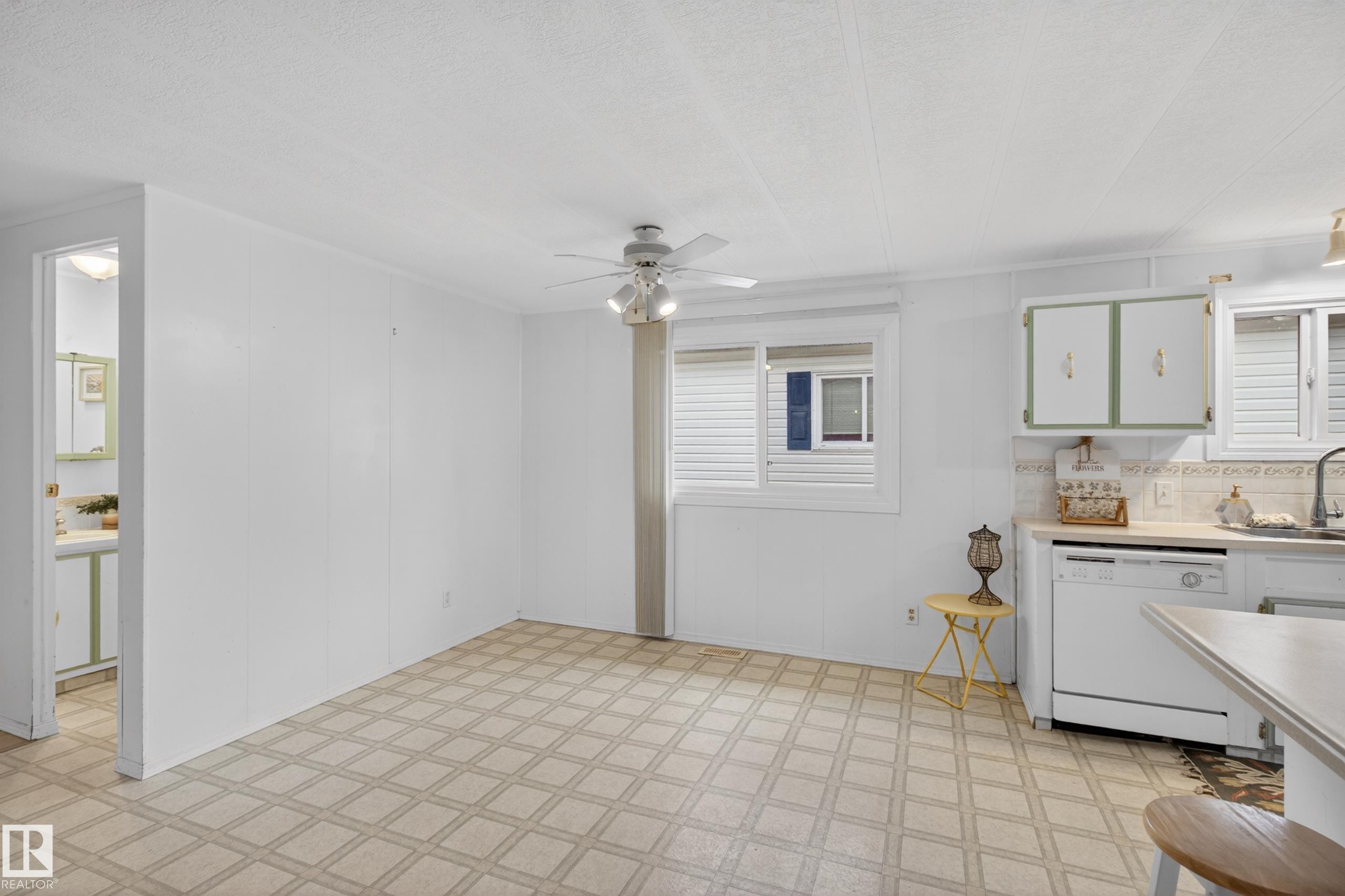 Kitchen area with white paneled walls, patterned tile flooring, and a ceiling fan - 21 Willowdale Drive, Edmonton, AB - Indoor Photo Showing Kitchen