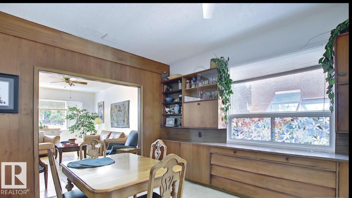 Dining area featuring built-in wood cabinetry with integrated storage and open shelving - 10017 113 Street, Edmonton, AB