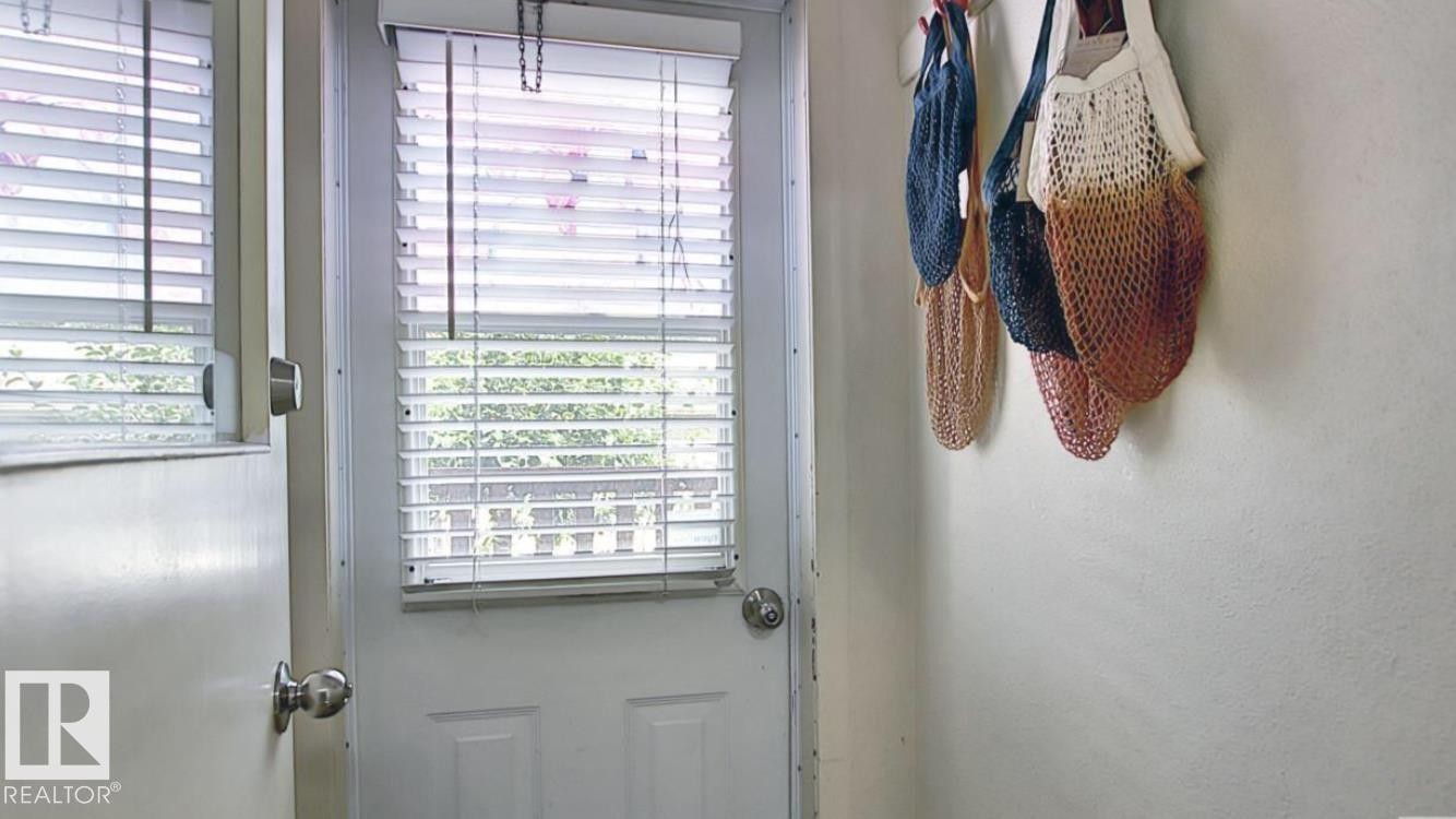White paneled exterior door with inset window and horizontal blinds - 10017 113 Street, Edmonton, AB