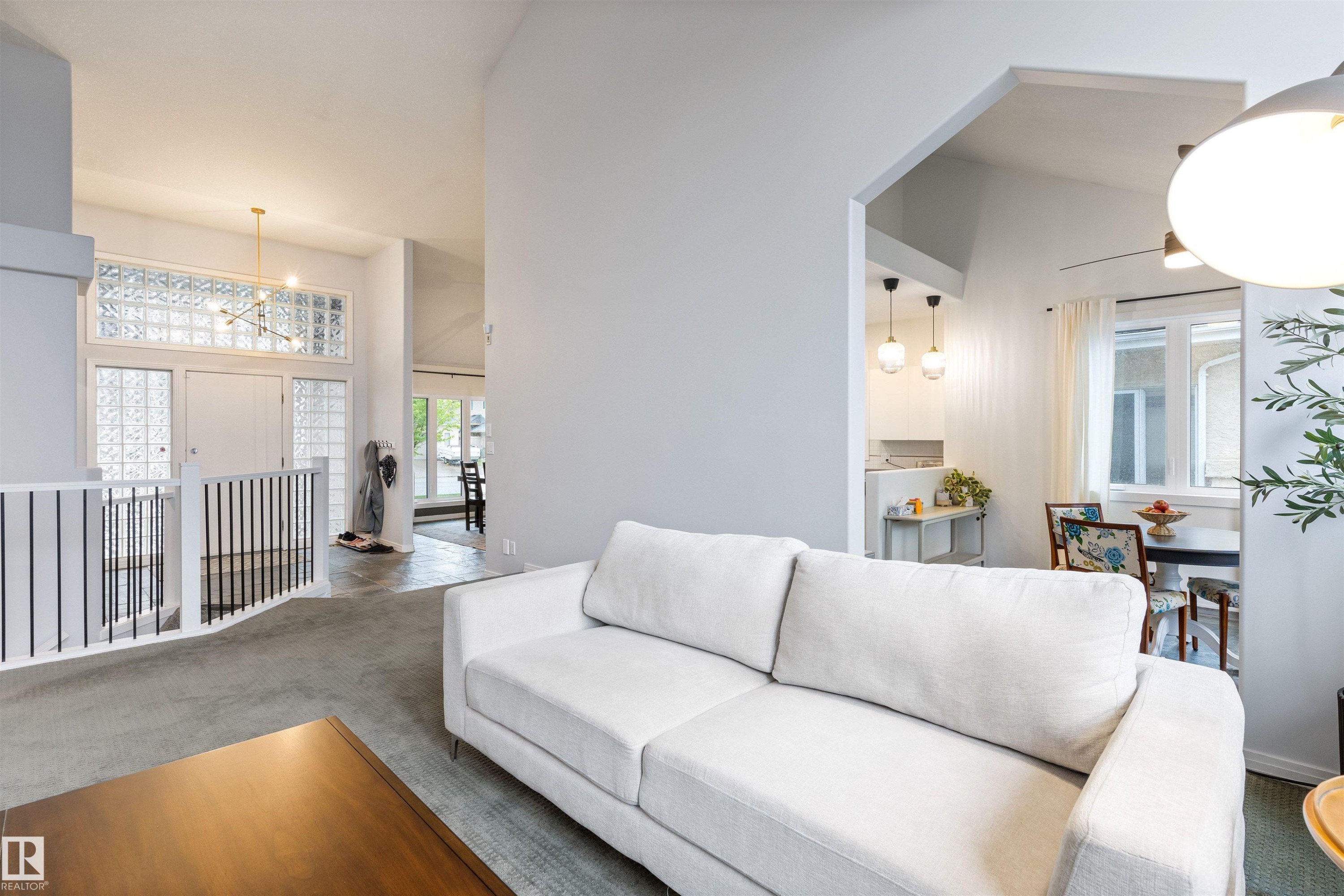 Vaulted ceilings accentuating a bright entryway with a modern chandelier and glass block detailing - 10 Everest Crescent, St. Albert, AB