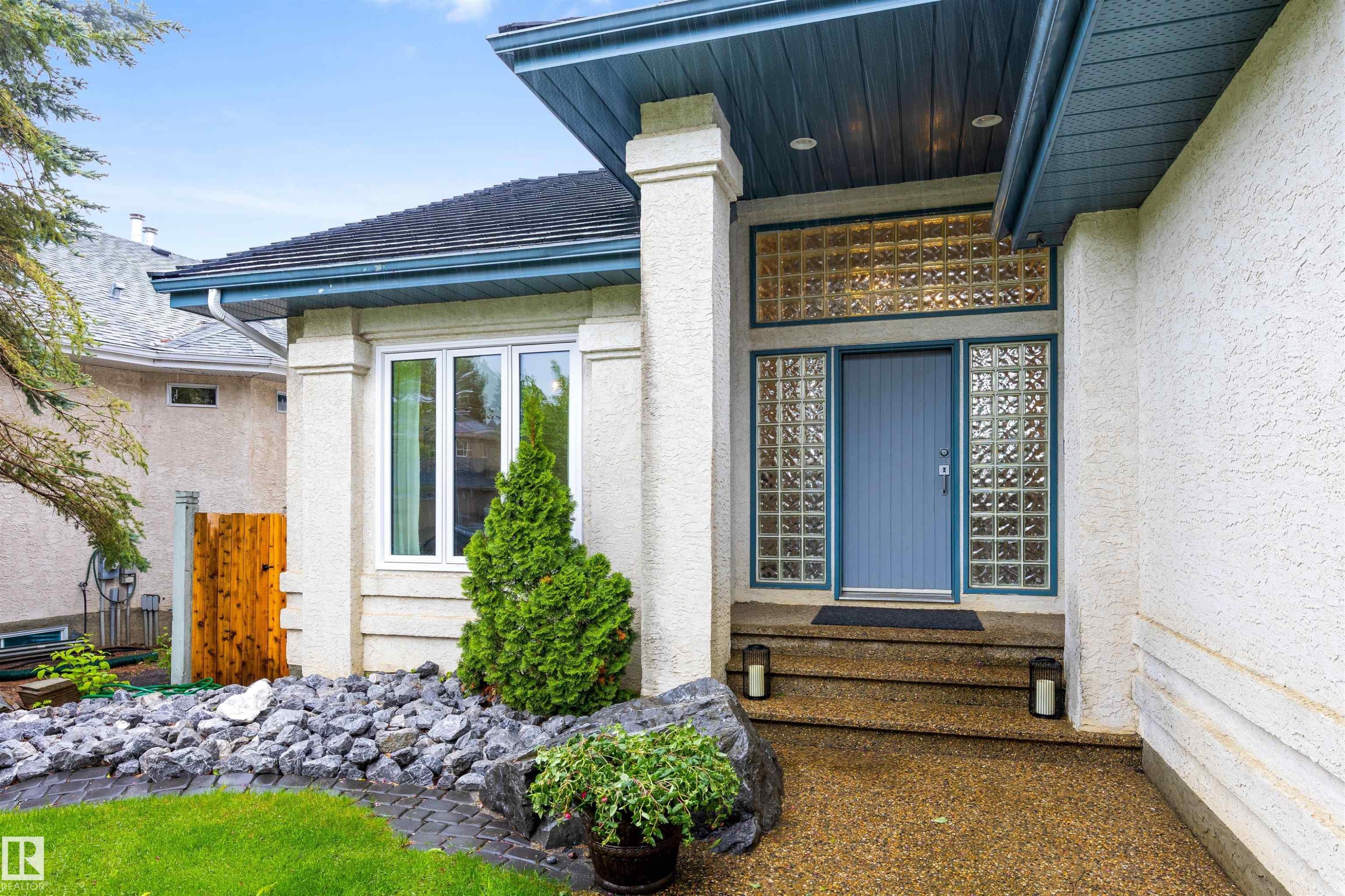 Entryway featuring a blue door flanked by glass block sidelights and a transom - 10 Everest Crescent, St. Albert, AB