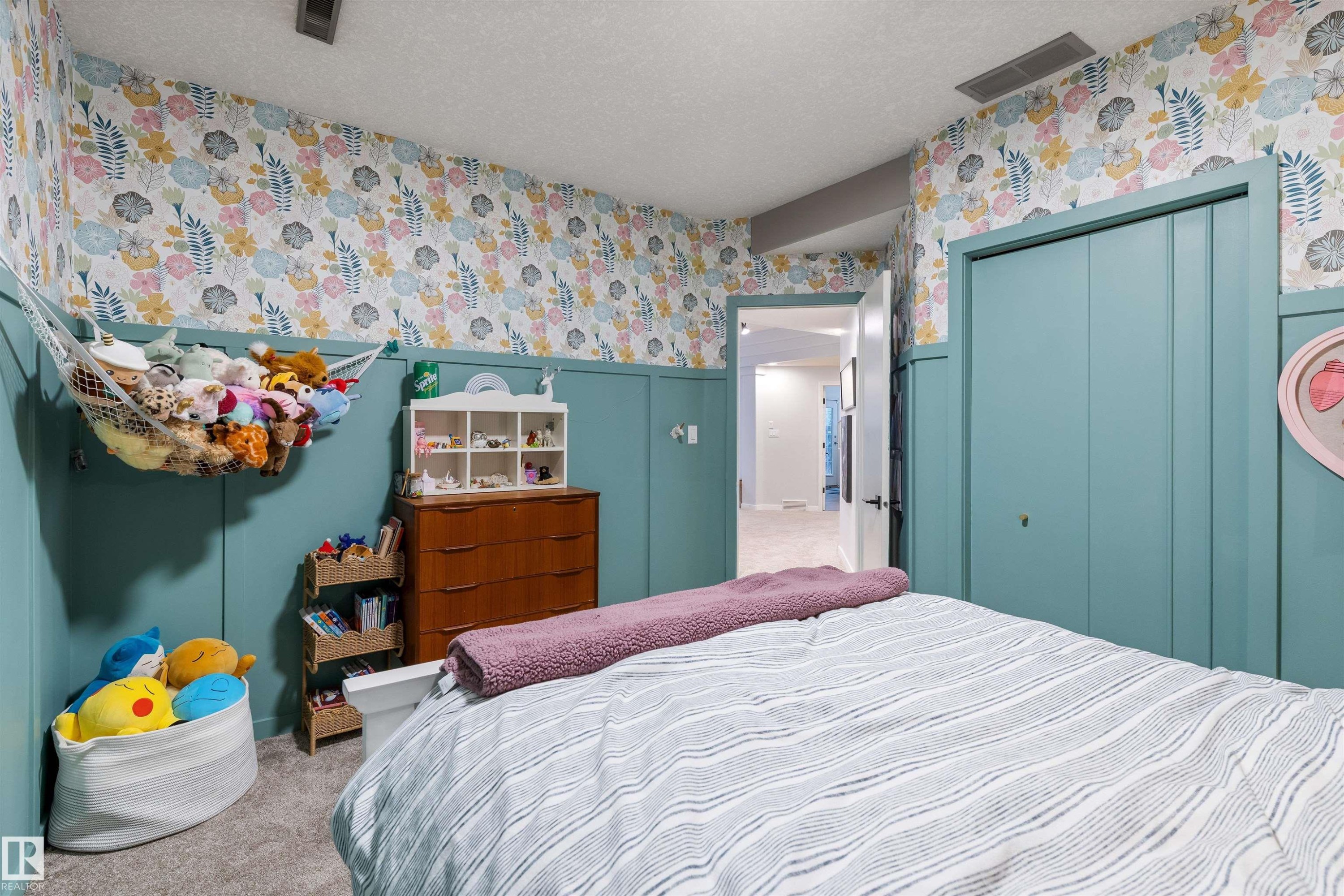 Room featuring board and batten wall detailing, floral wallpaper, and neutral carpeting - 10 Everest Crescent, St. Albert, AB