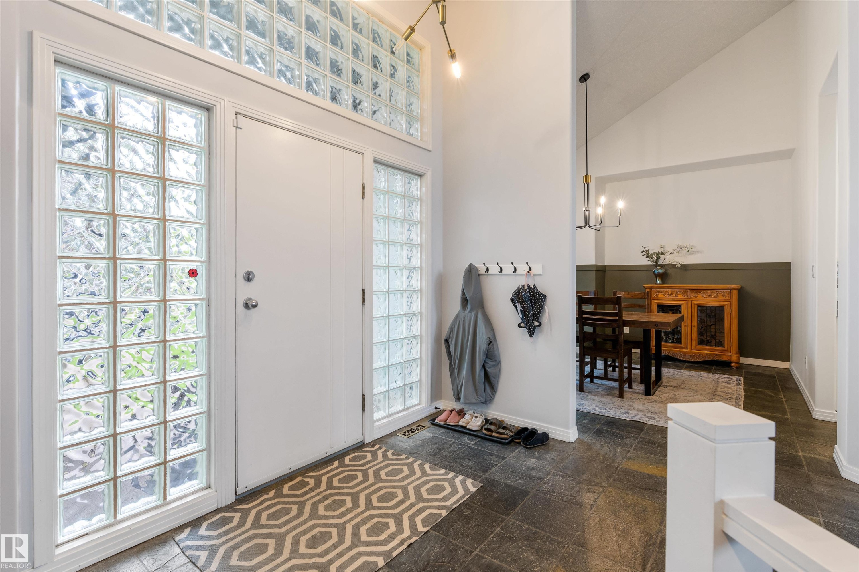 Entryway featuring glass block sidelights and transom, dark slate tile flooring, and a vaulted ceiling - 10 Everest Crescent, St. Albert, AB