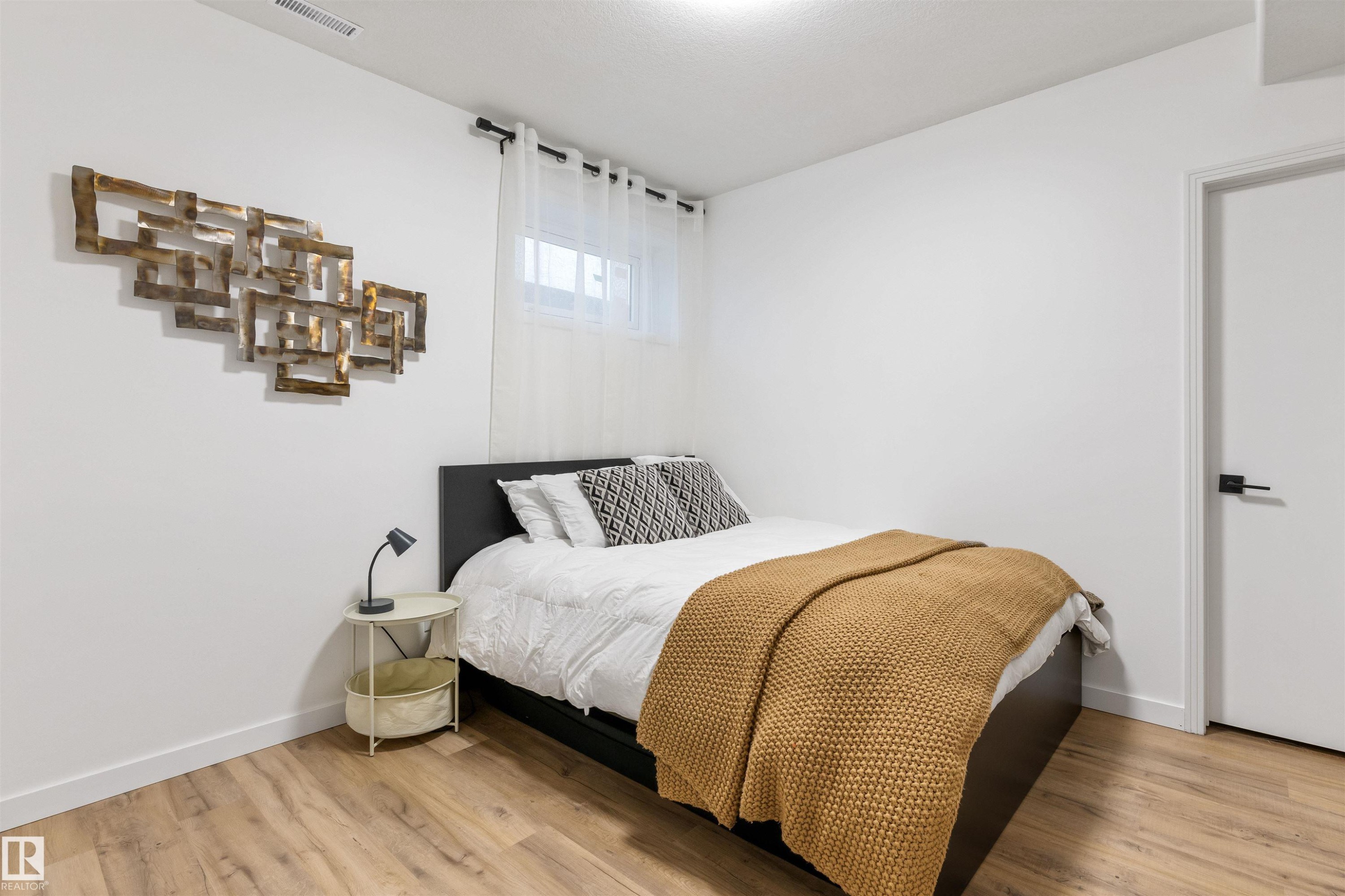 Bright room featuring light wood-finish flooring, white walls, and a recessed window with sheer curtains - 10 Everest Crescent, St. Albert, AB