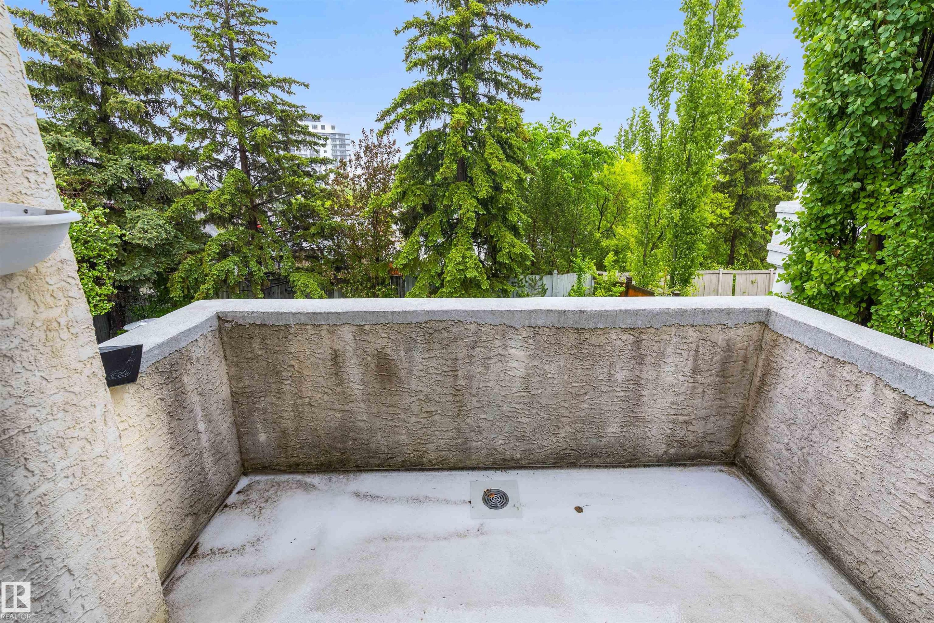 Outdoor balcony with textured stucco walls, concrete flooring, and a perimeter railing - 10 Everest Crescent, St. Albert, AB