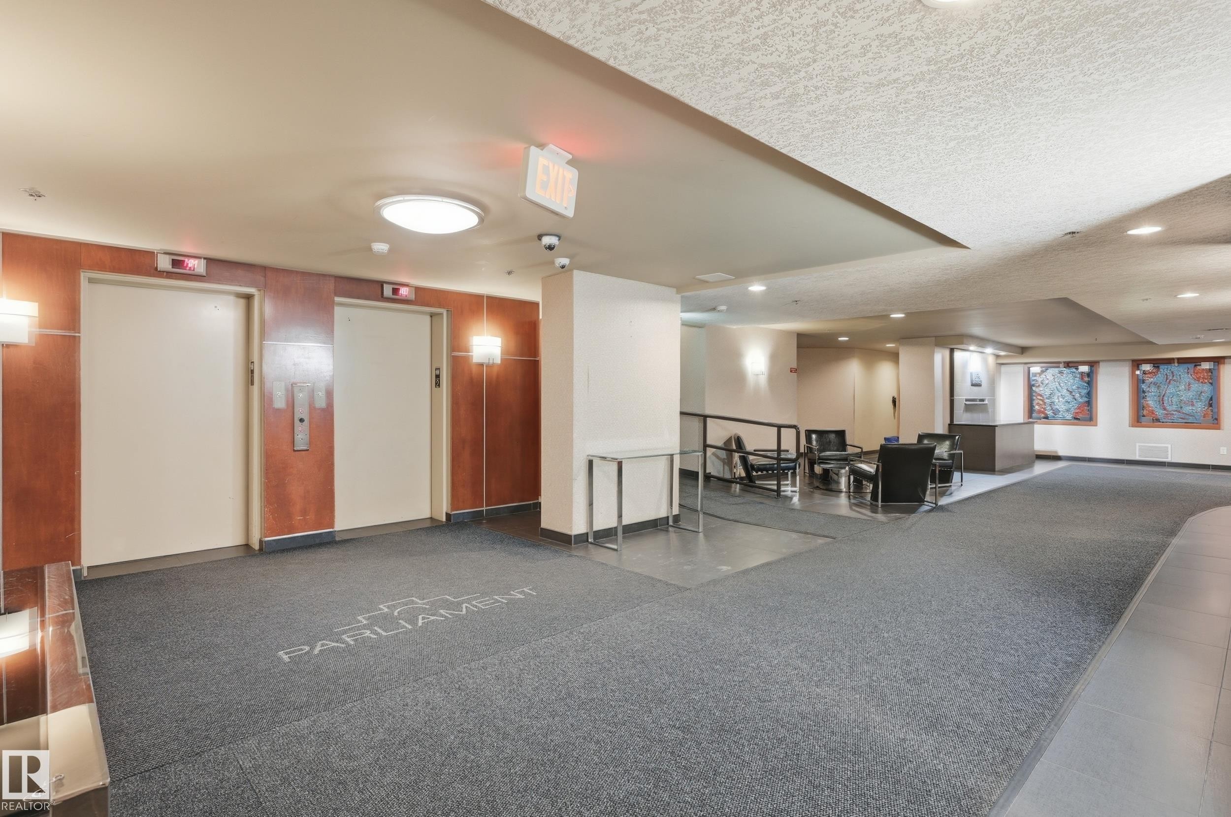 Building lobby featuring two elevators with wood-paneled surrounds - #1407 9939 109 St Nw, Edmonton, AB