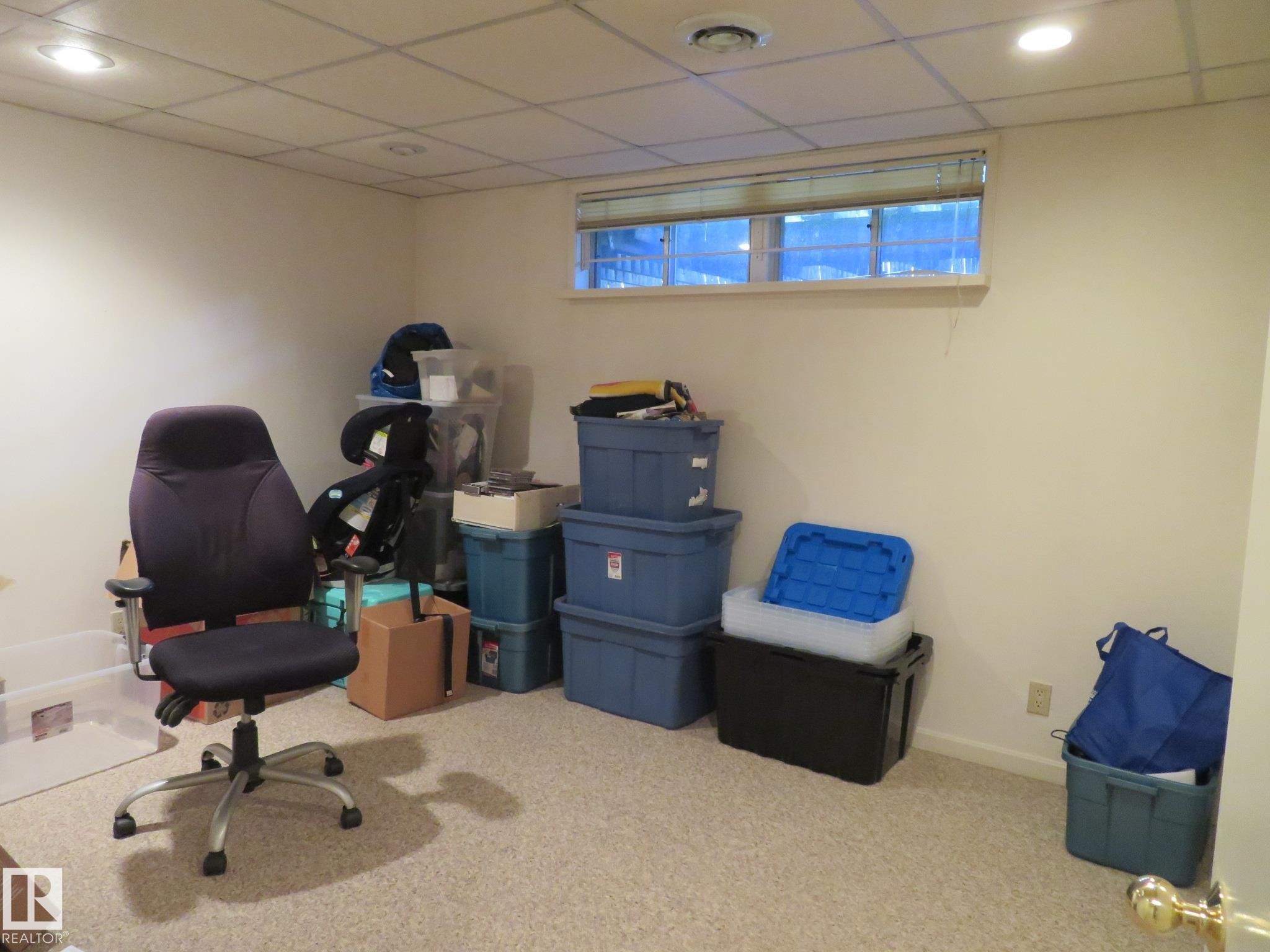 Finished room featuring a drop ceiling with recessed lighting, carpet flooring, a single window with blinds, and painted walls - 10720 57 Avenue Nw, Edmonton, AB - Indoor