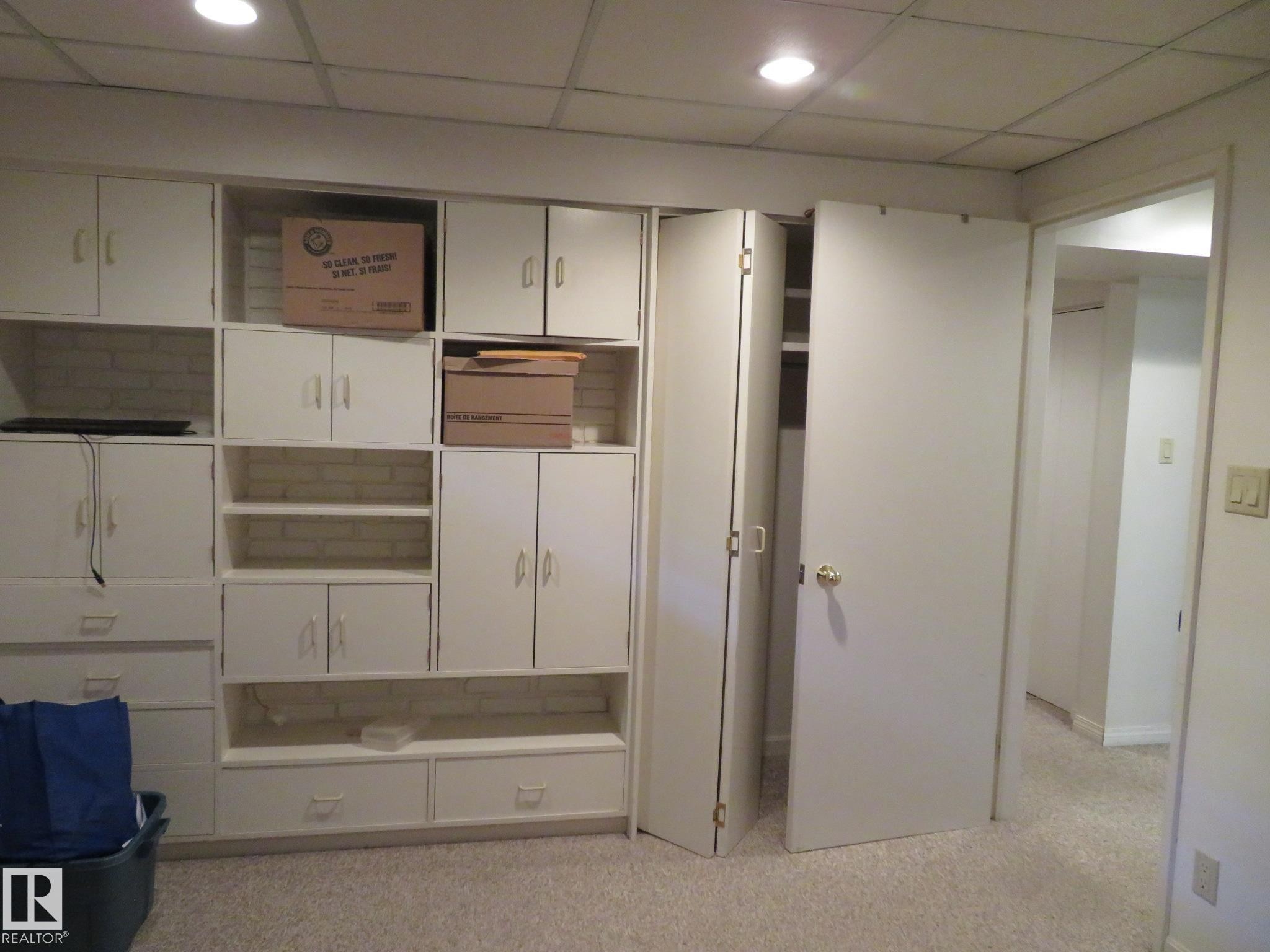 Wall-to-wall built-in cabinetry with white shaker-style doors, integrated open shelving, and drawer storage - 10720 57 Avenue Nw, Edmonton, AB - Indoor