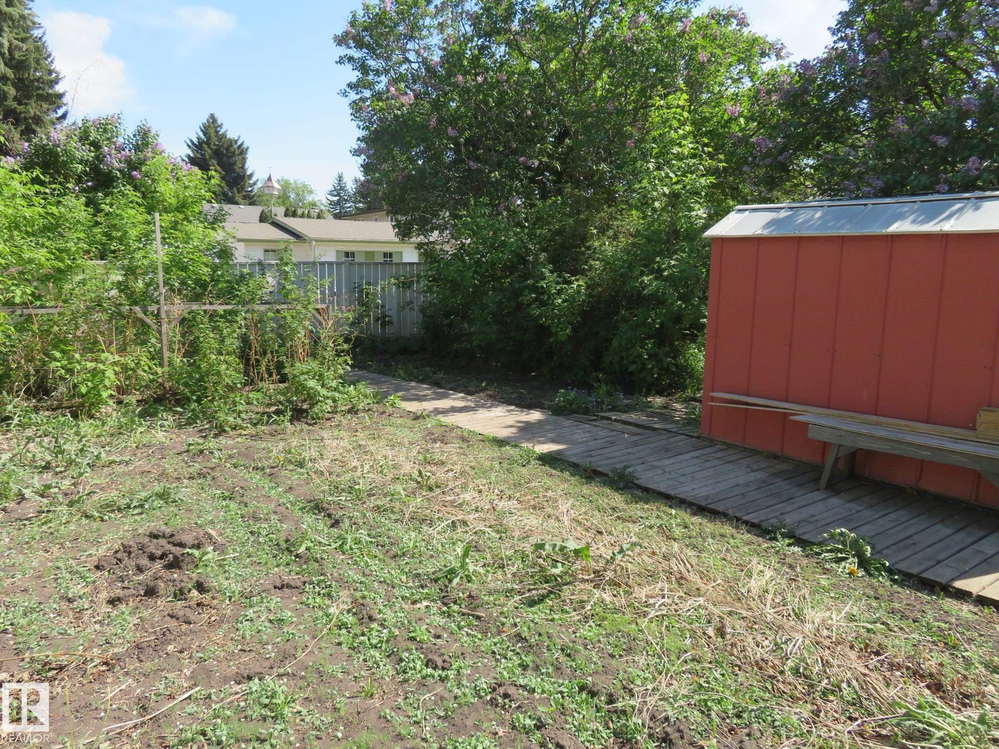 Exterior featuring a red shed with a metal roof and an attached wooden bench - 10720 57 Avenue Nw, Edmonton, AB - Outdoor