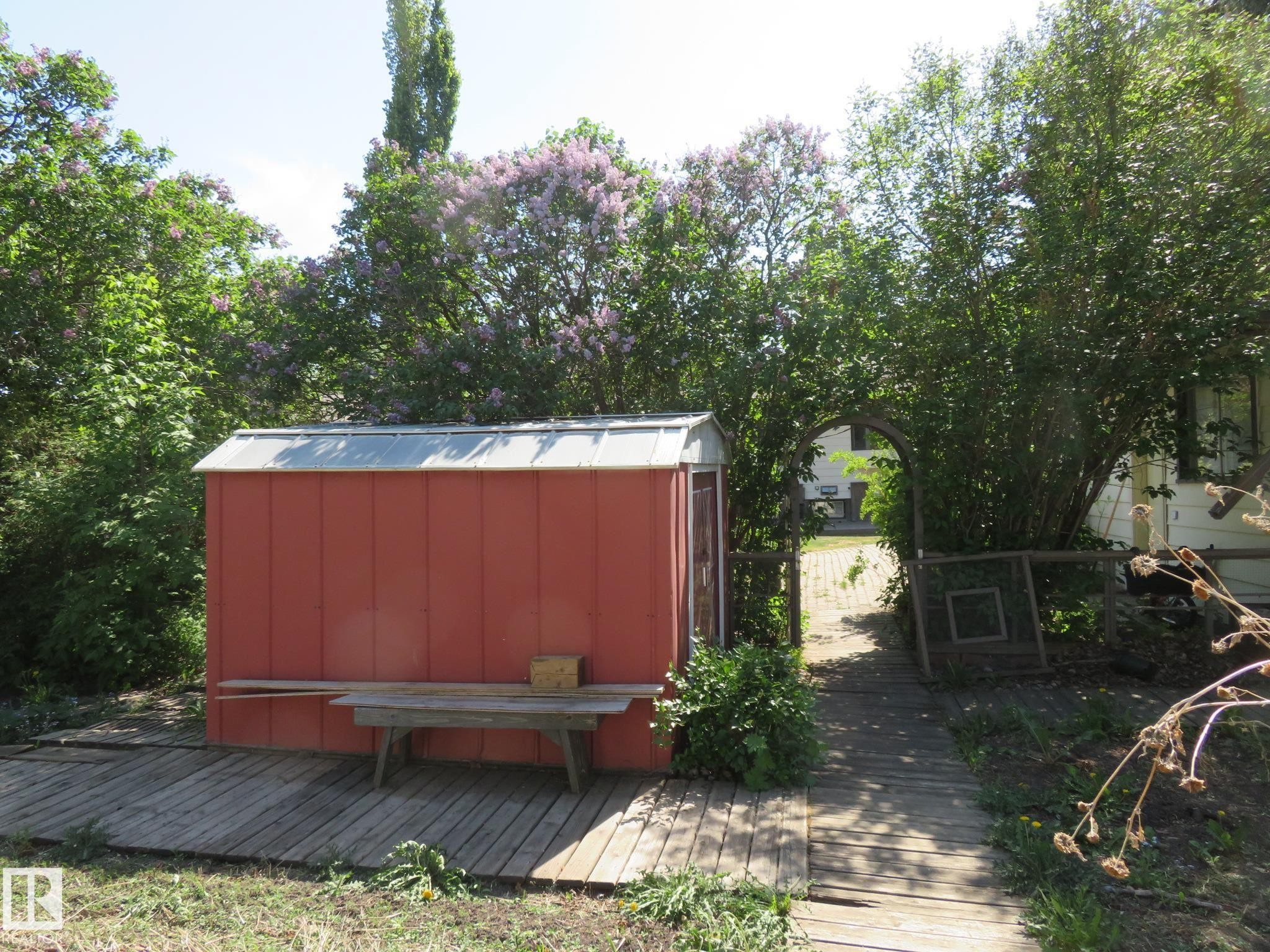 Red storage shed with a metal roof, situated on a wood-plank deck - 10720 57 Avenue Nw, Edmonton, AB - Outdoor