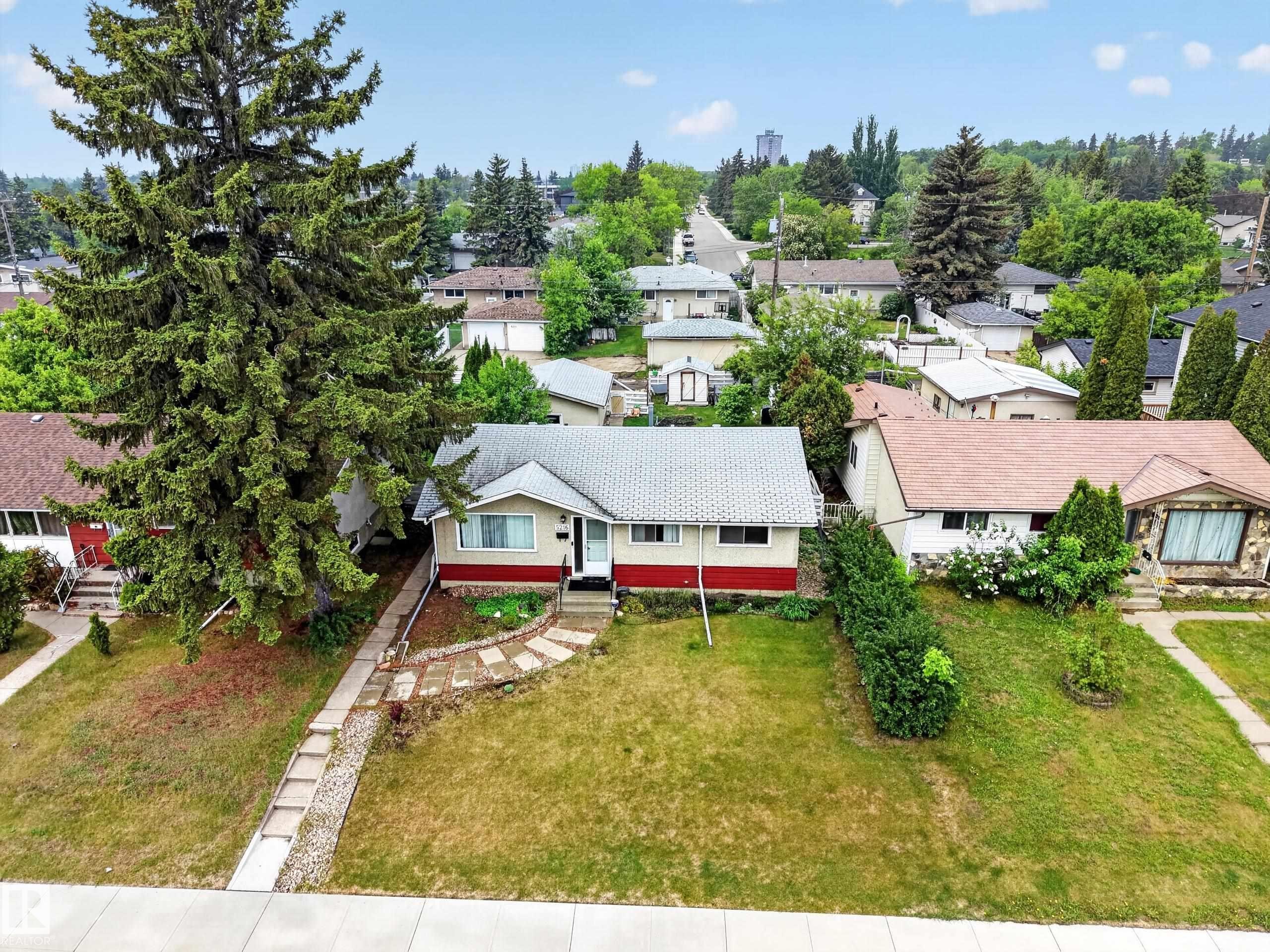 Single-story residence featuring a light-colored exterior with a red accent band and a light gray shingle roof - 5216 104A Street, Edmonton, AB - Outdoor
