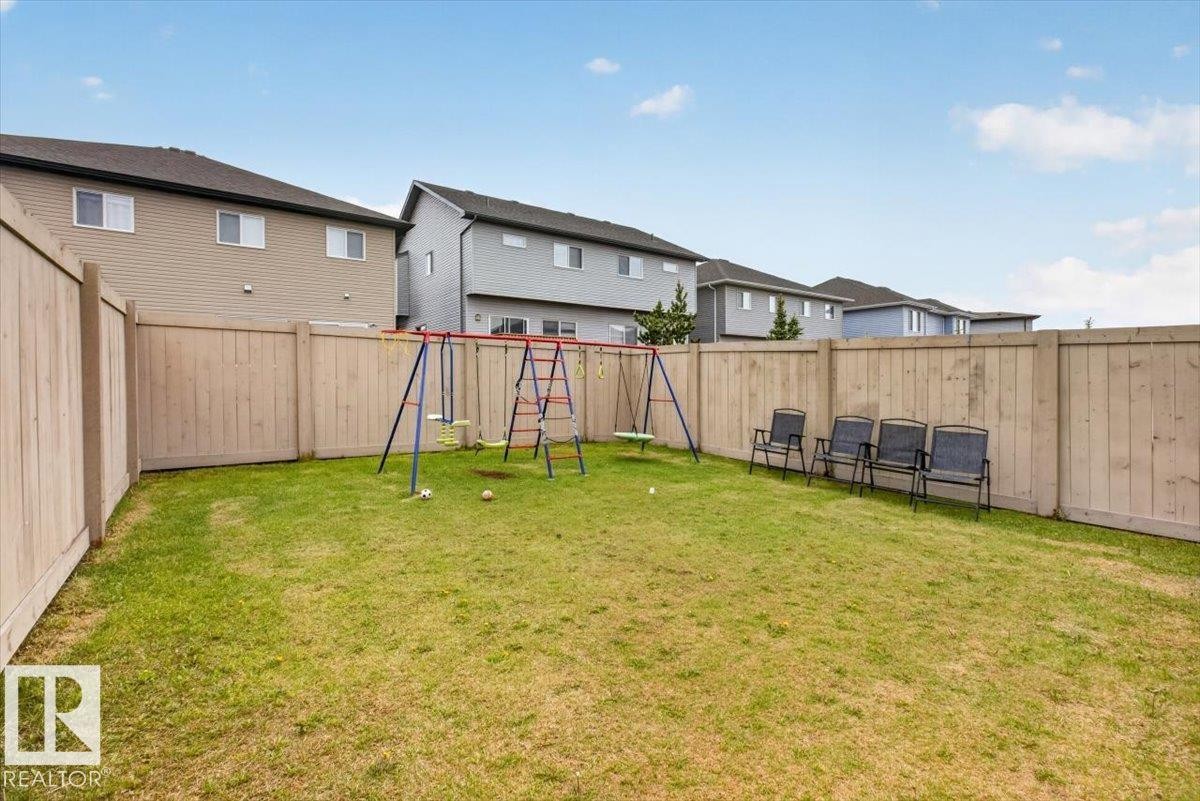 Expansive backyard featuring a green lawn, wood fence perimeter, and clear sky overhead - 223 40A Avenue, Edmonton, AB - Outdoor