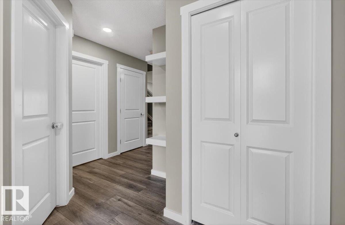 Hallway featuring wood-finish flooring, recessed lighting, white panel doors, and built-in shelving - 223 40A Avenue, Edmonton, AB - Indoor Photo Showing Other Room