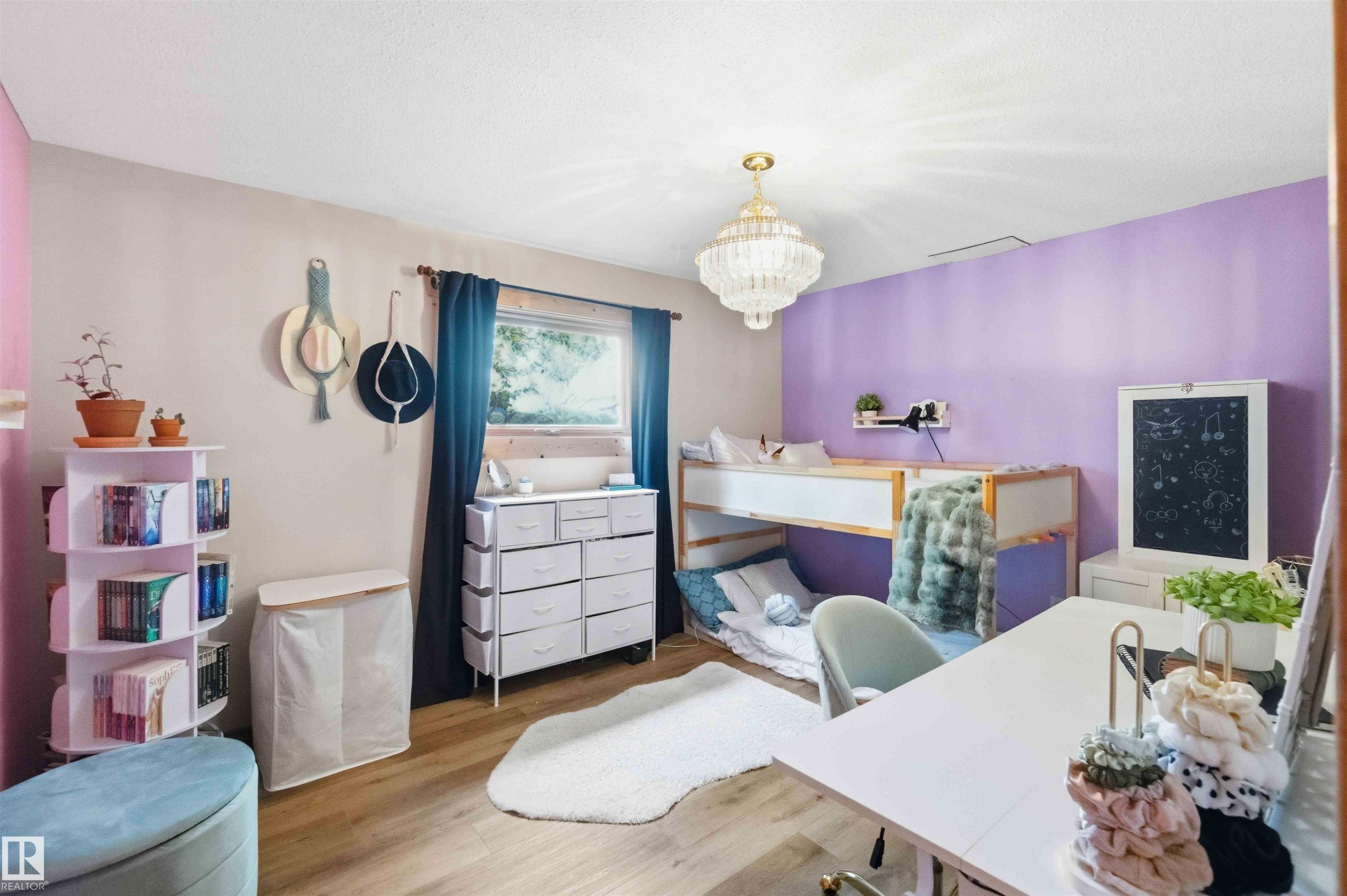 Room featuring multi-toned walls, wood-finish flooring, a window with dark curtains, and a decorative ceiling light fixture - #17 A 15031 Twp Road 462, Rural Wetaskiwin County, AB - Indoor Photo Showing Bedroom