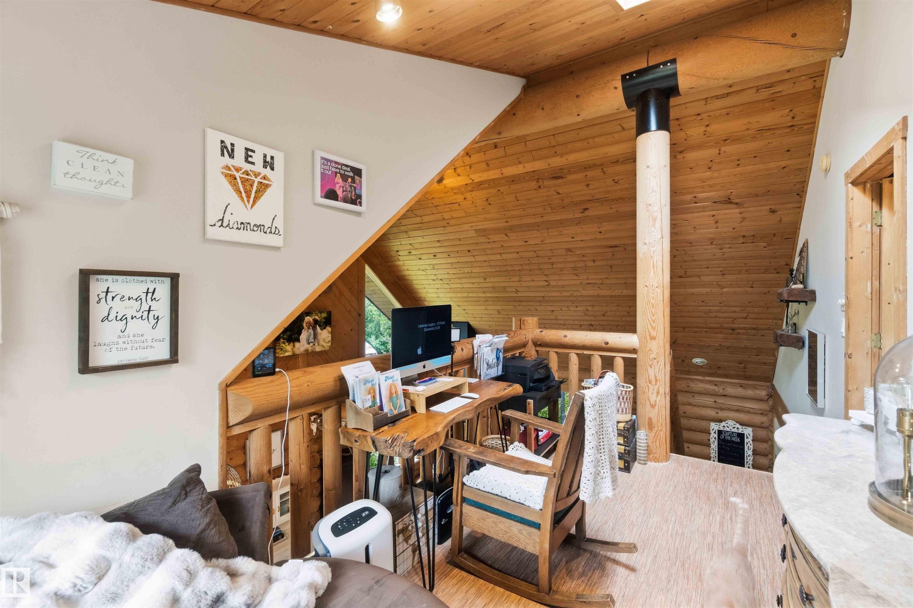 Loft area featuring sloped wood-paneled ceilings, a prominent wood column, and wood-finish flooring - #17 A 15031 Twp Road 462, Rural Wetaskiwin County, AB - Indoor
