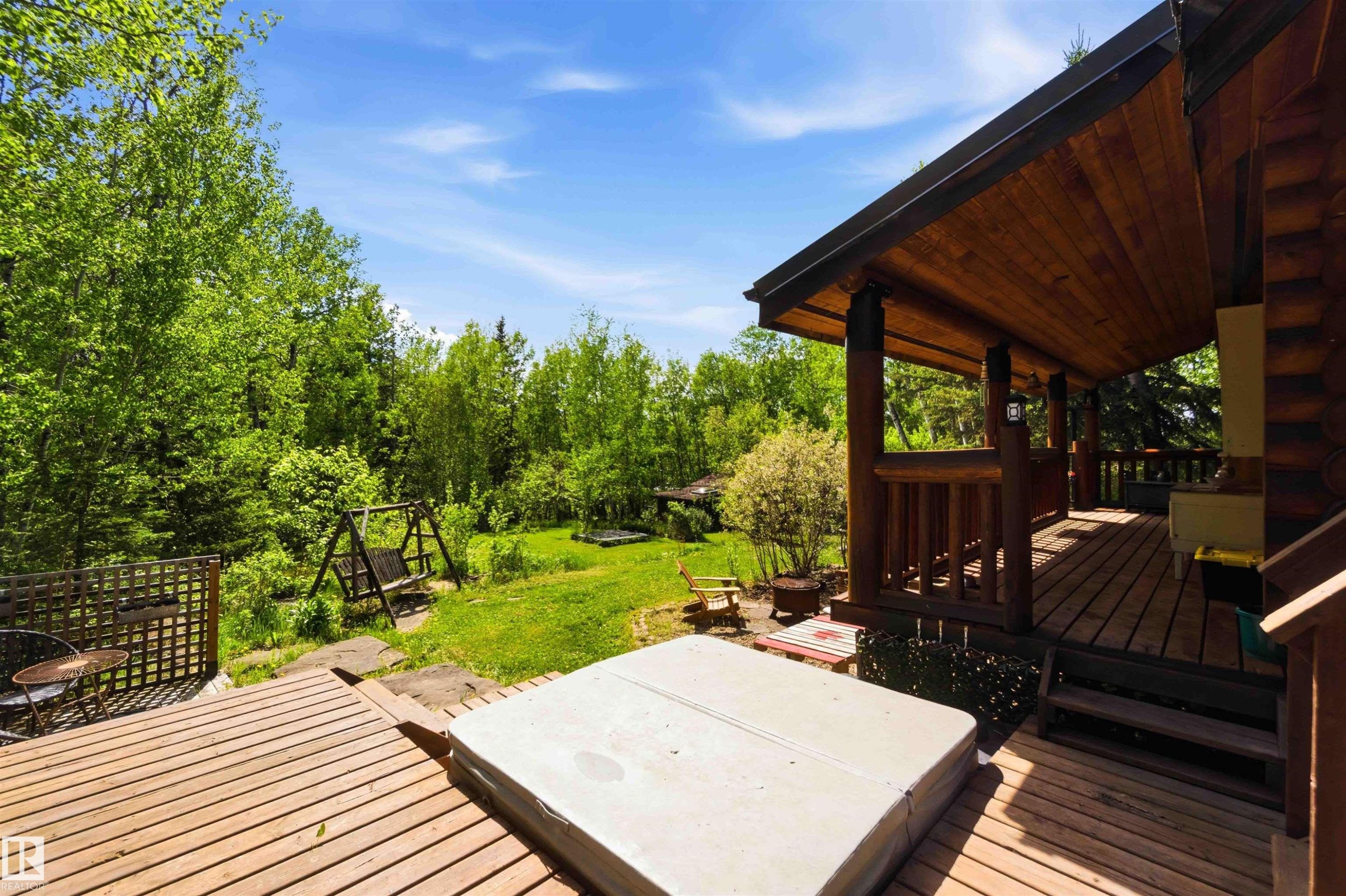 Expansive outdoor living area featuring a covered porch with exposed wood ceiling, a large wood deck, and a built-in spa - #17 A 15031 Twp Road 462, Rural Wetaskiwin County, AB - Outdoor With Deck Patio Veranda With Exterior