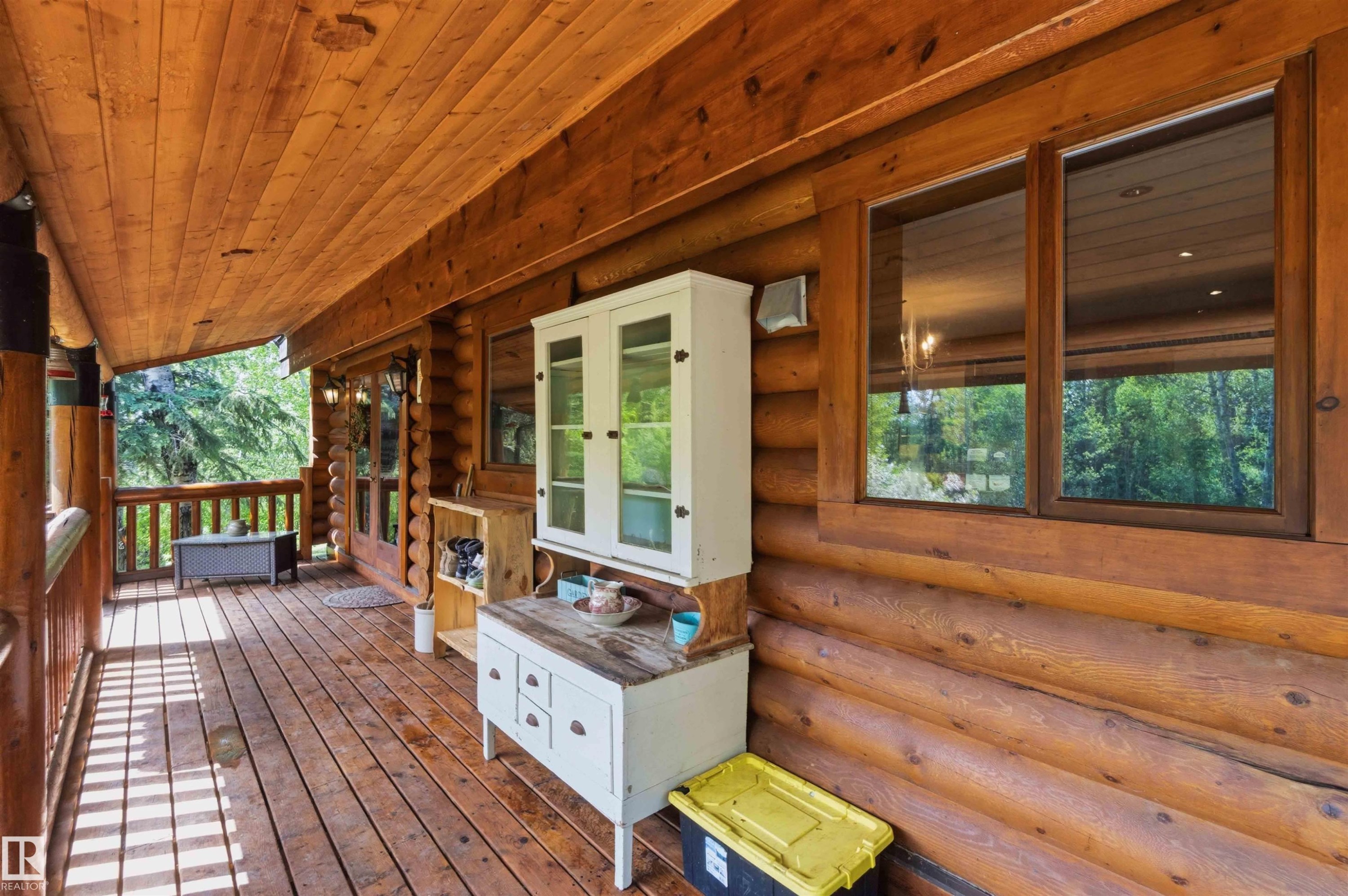 Expansive covered porch featuring wood-finish flooring, log cabin exterior, and wood-framed windows - #17 A 15031 Twp Road 462, Rural Wetaskiwin County, AB - Outdoor With Deck Patio Veranda With Exterior