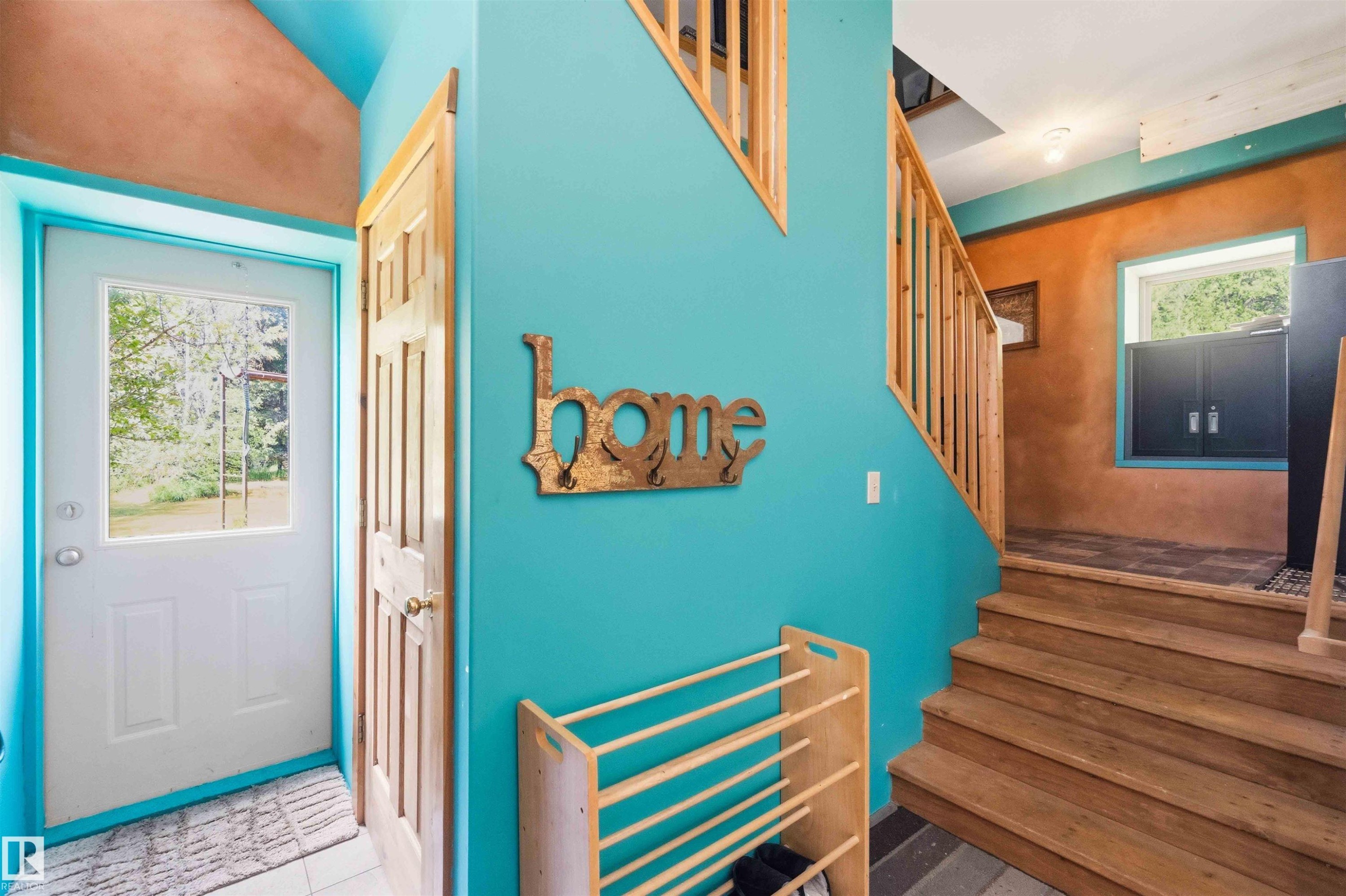 Entryway featuring a paneled door with a window, tile flooring, and a natural wood staircase with balusters - #17 A 15031 Twp Road 462, Rural Wetaskiwin County, AB - Outdoor With Deck Patio Veranda With Exterior