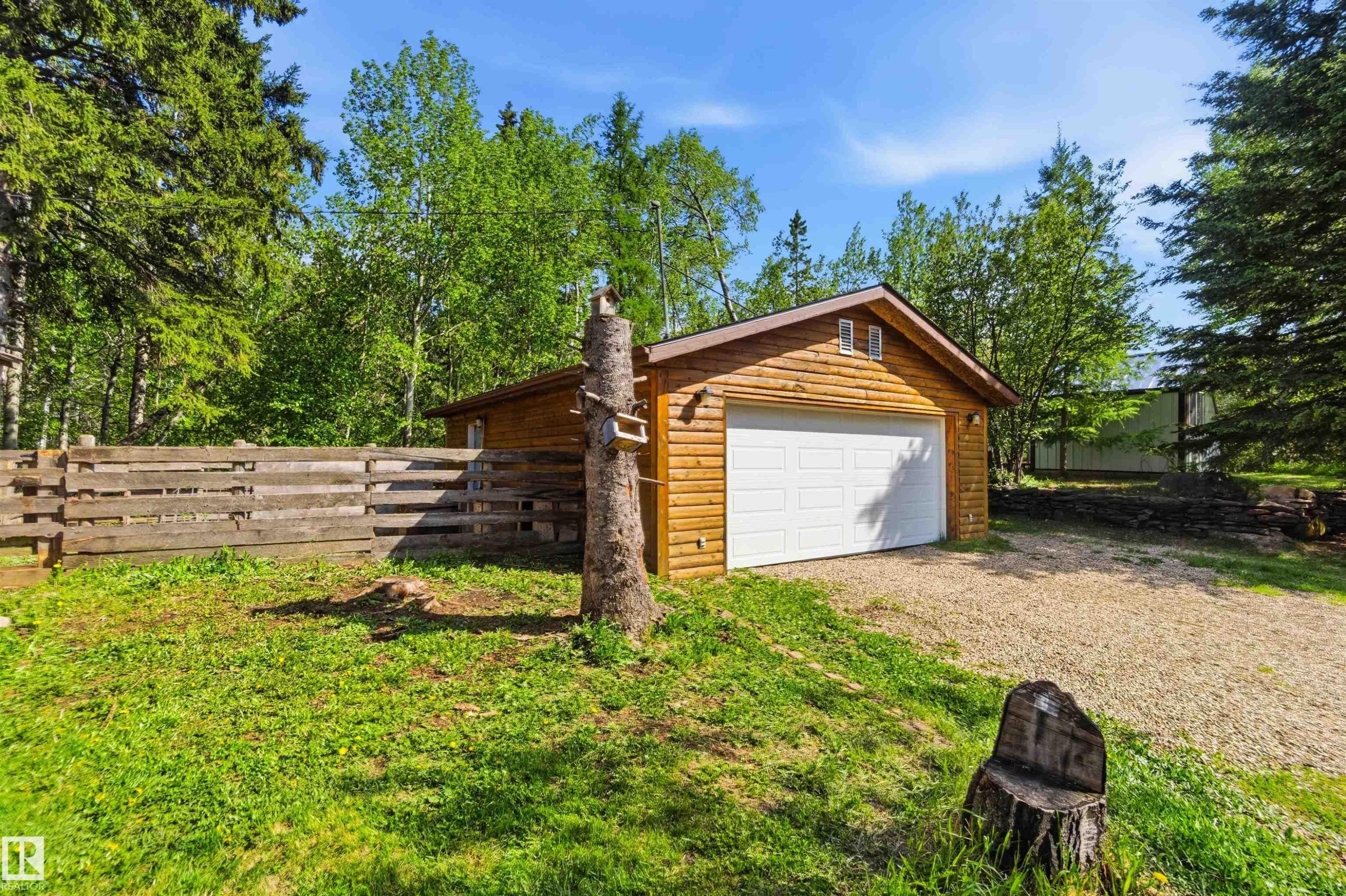 Detached wooden garage with a white overhead door and twin attic windows - #17 A 15031 Twp Road 462, Rural Wetaskiwin County, AB - Outdoor