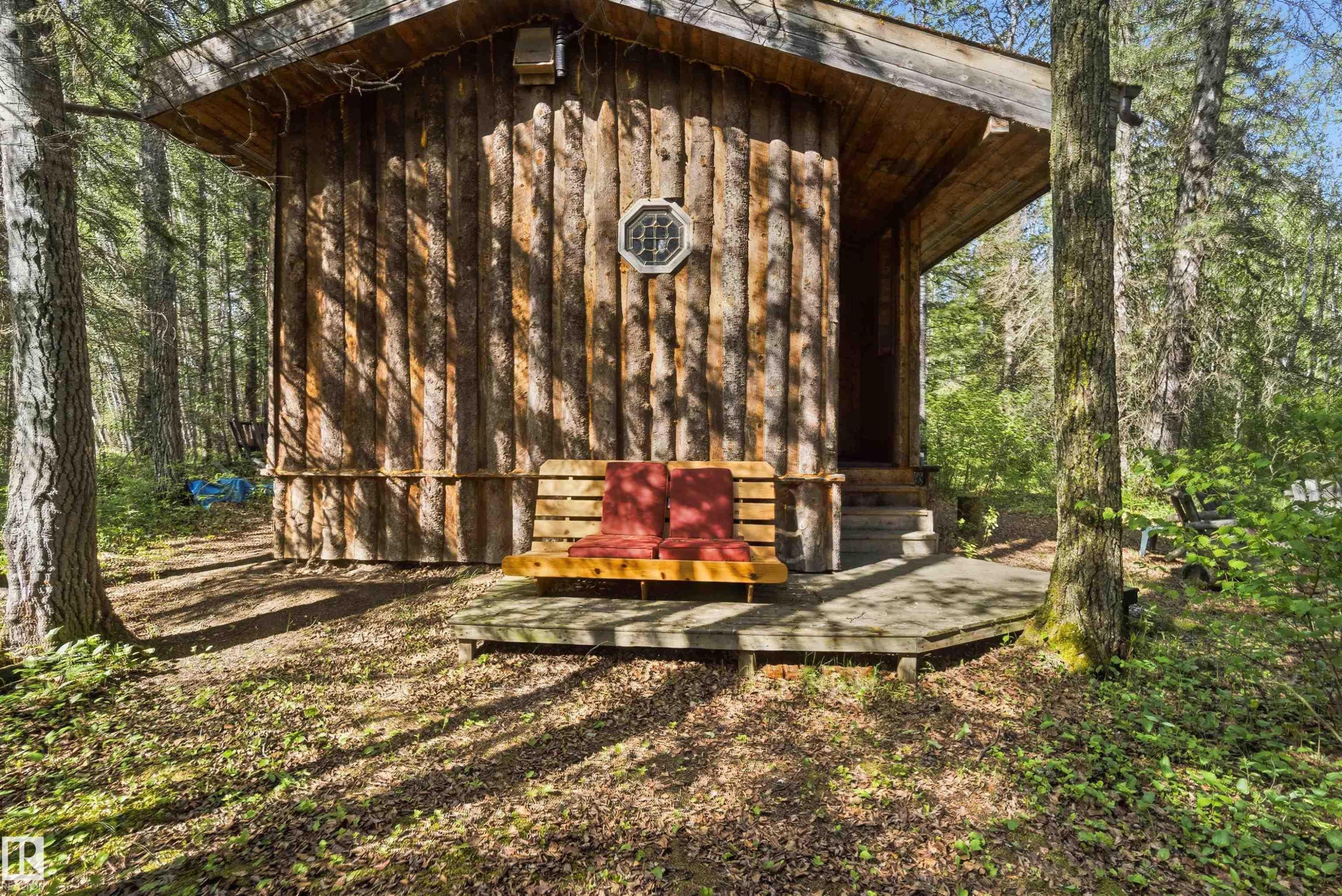Log cabin exterior with an octagonal window and covered porch - #17 A 15031 Twp Road 462, Rural Wetaskiwin County, AB - Outdoor
