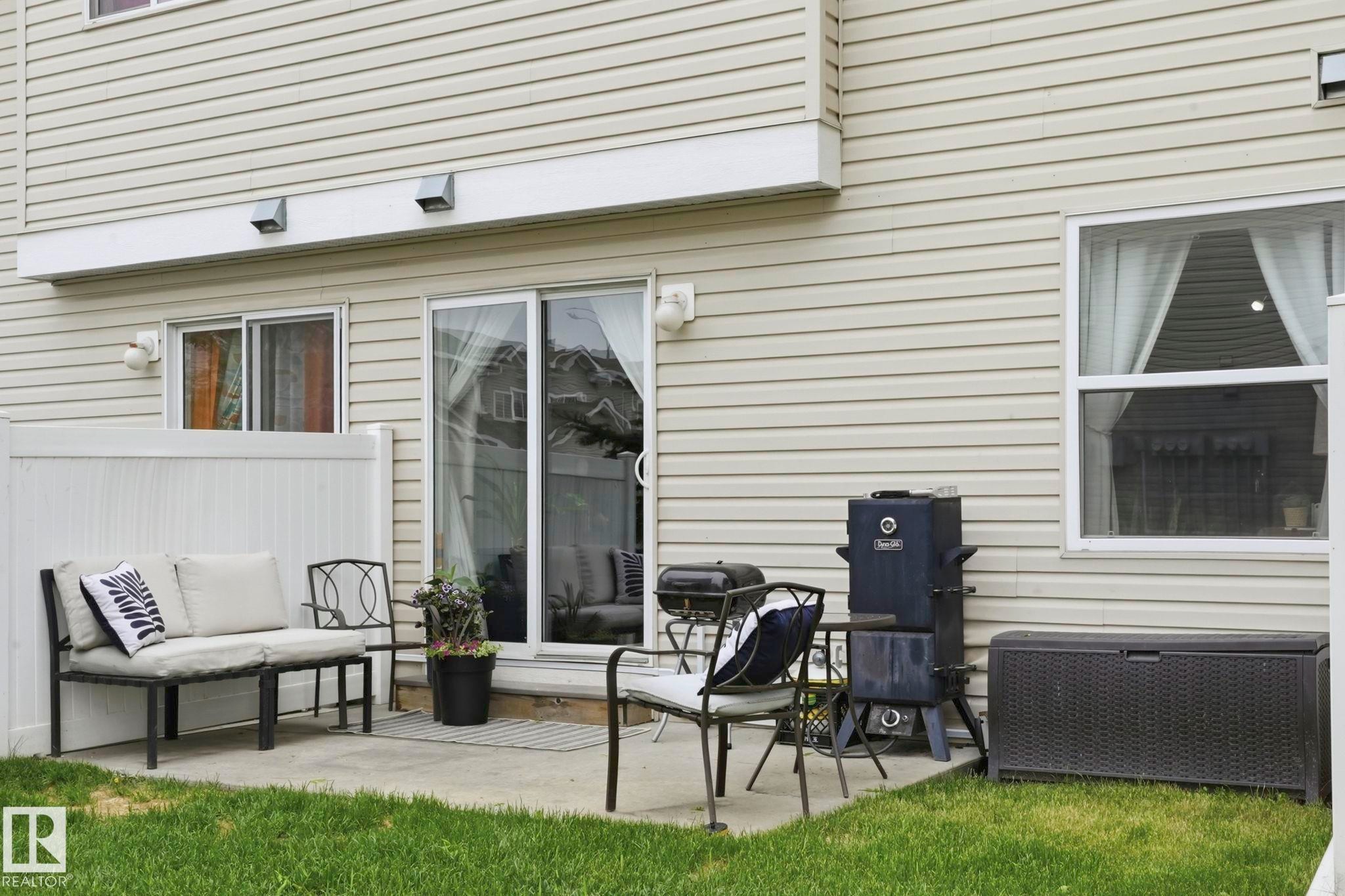 Concrete patio featuring a sliding glass door, an additional window, and horizontal vinyl siding - 164 150 Edwards Drive, Edmonton, AB - Outdoor With Exterior