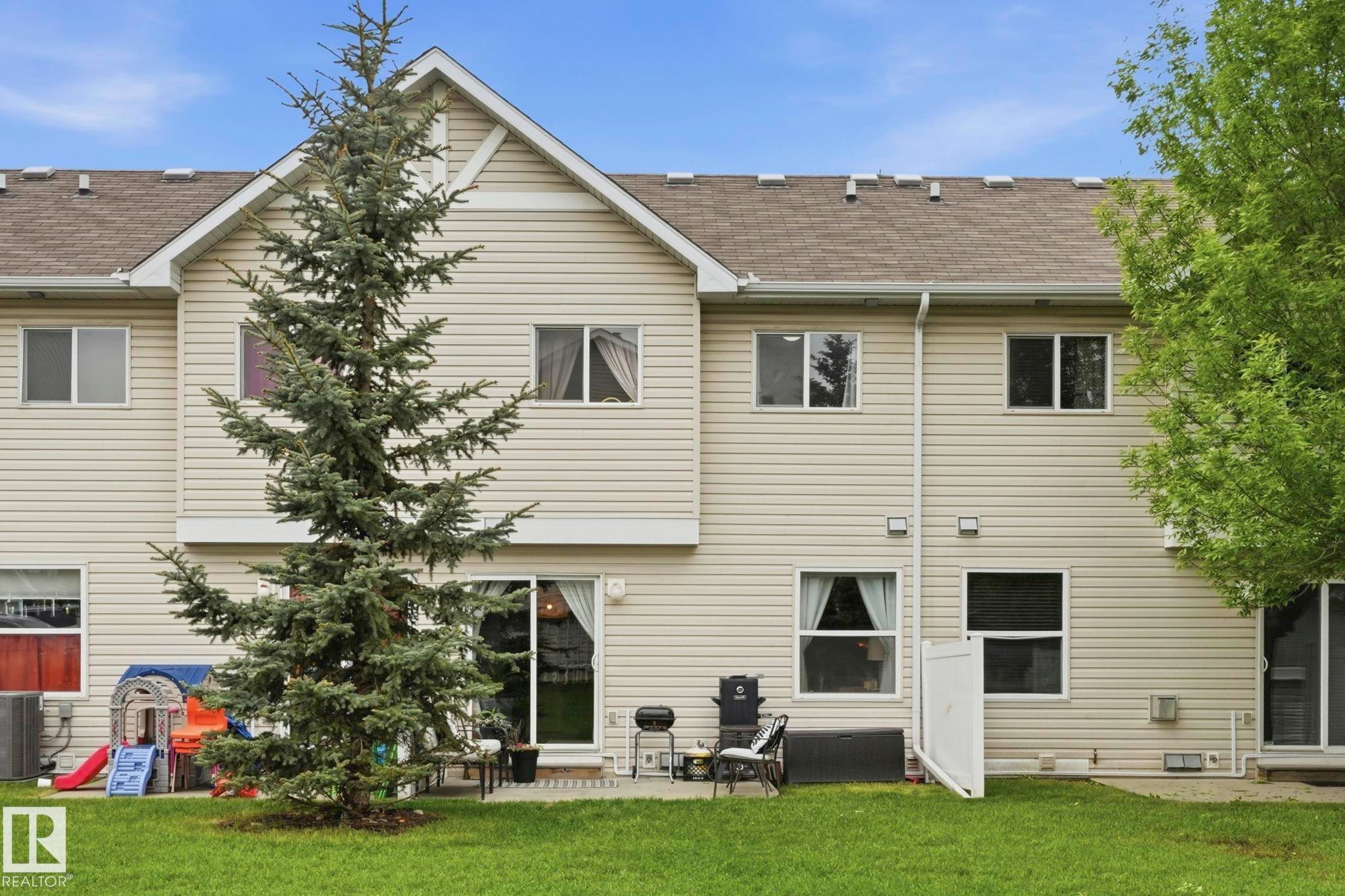 Rear exterior featuring light-toned horizontal siding and a gabled roofline - 164 150 Edwards Drive, Edmonton, AB - Outdoor With Exterior