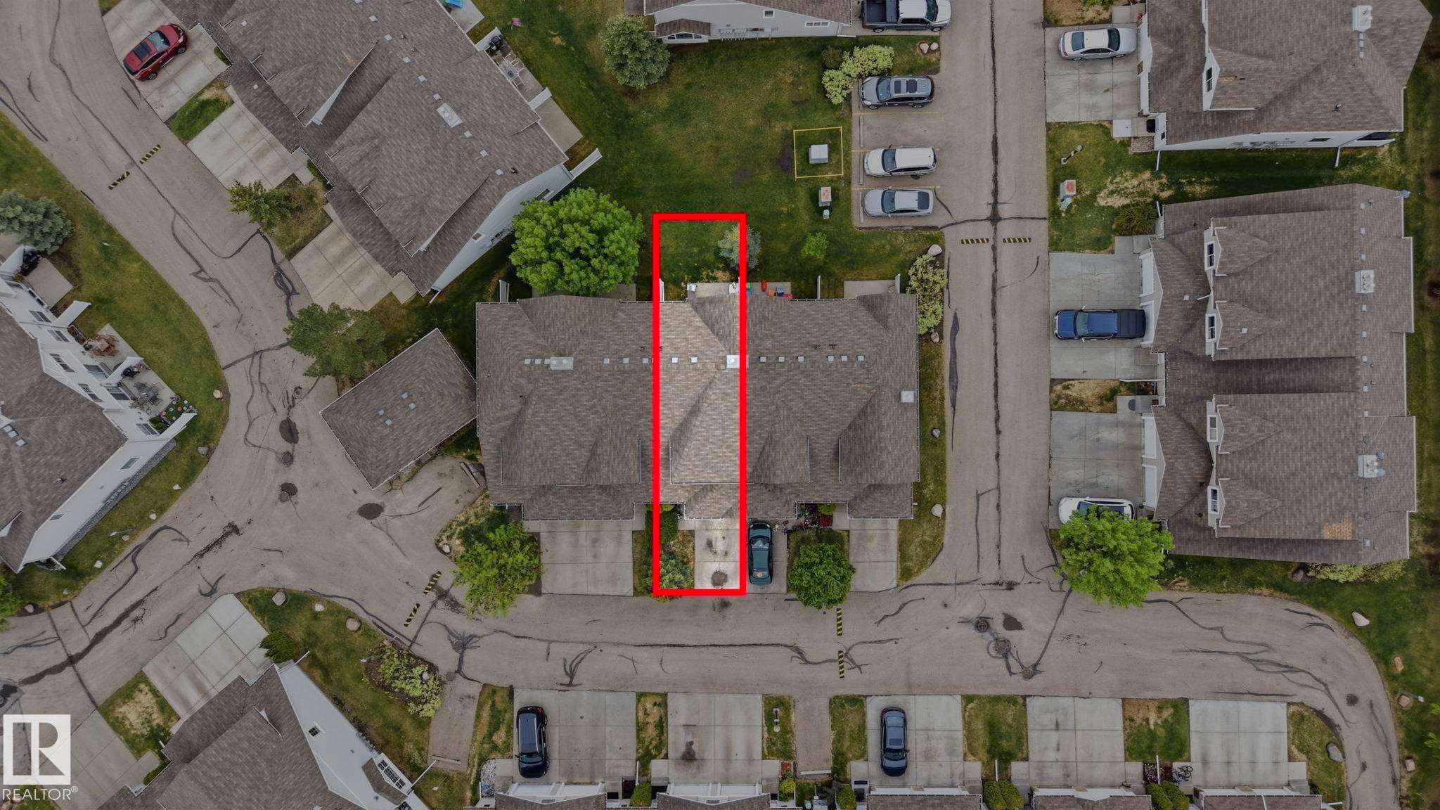Townhome property featuring a private driveway, attached garage, and a manicured rear lawn - 164 150 Edwards Drive, Edmonton, AB - With View