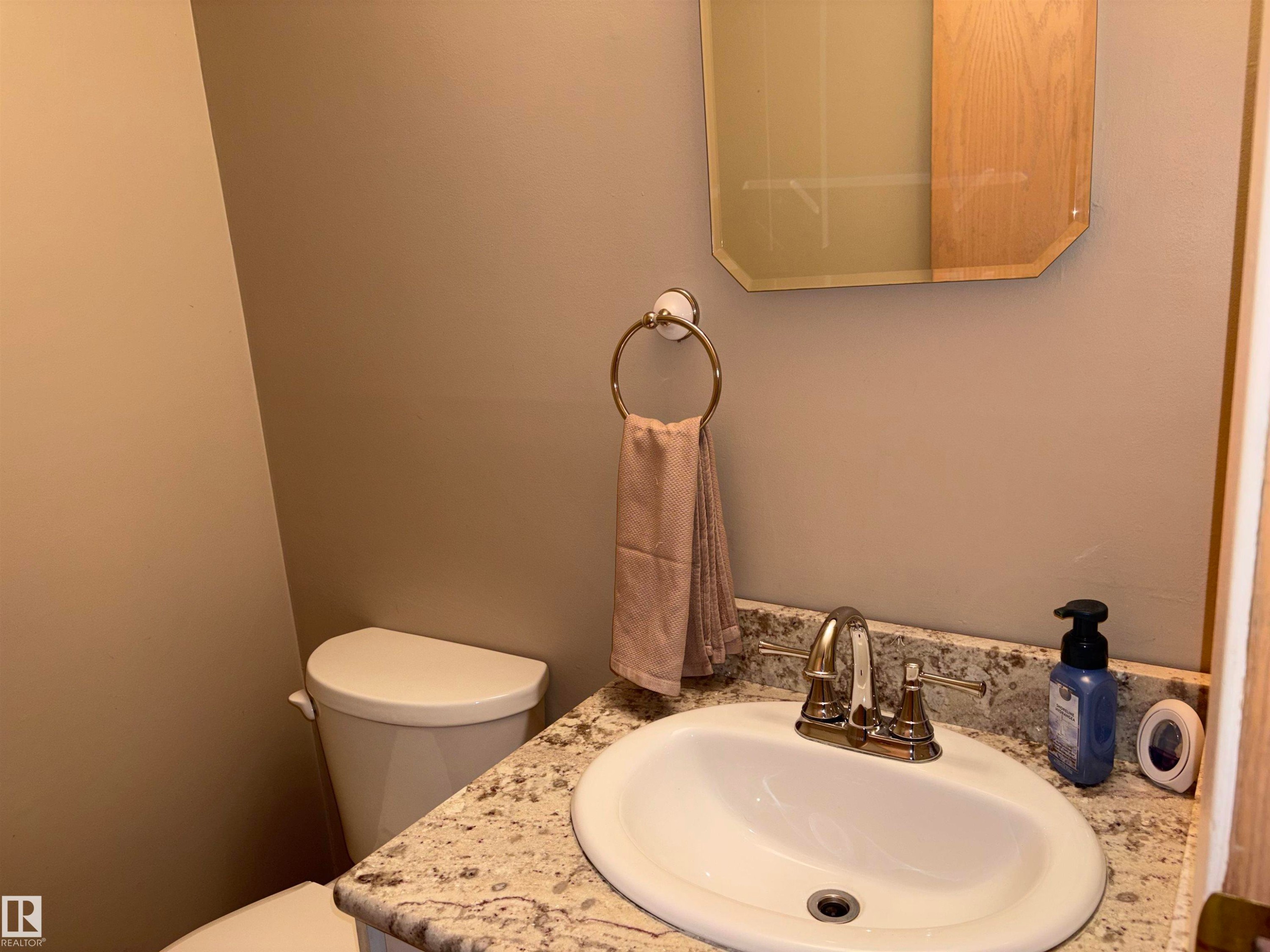 Bathroom vanity with a granite-style countertop and an integrated sink - 167 Ridgewood, St. Albert, AB - Indoor Photo Showing Bathroom