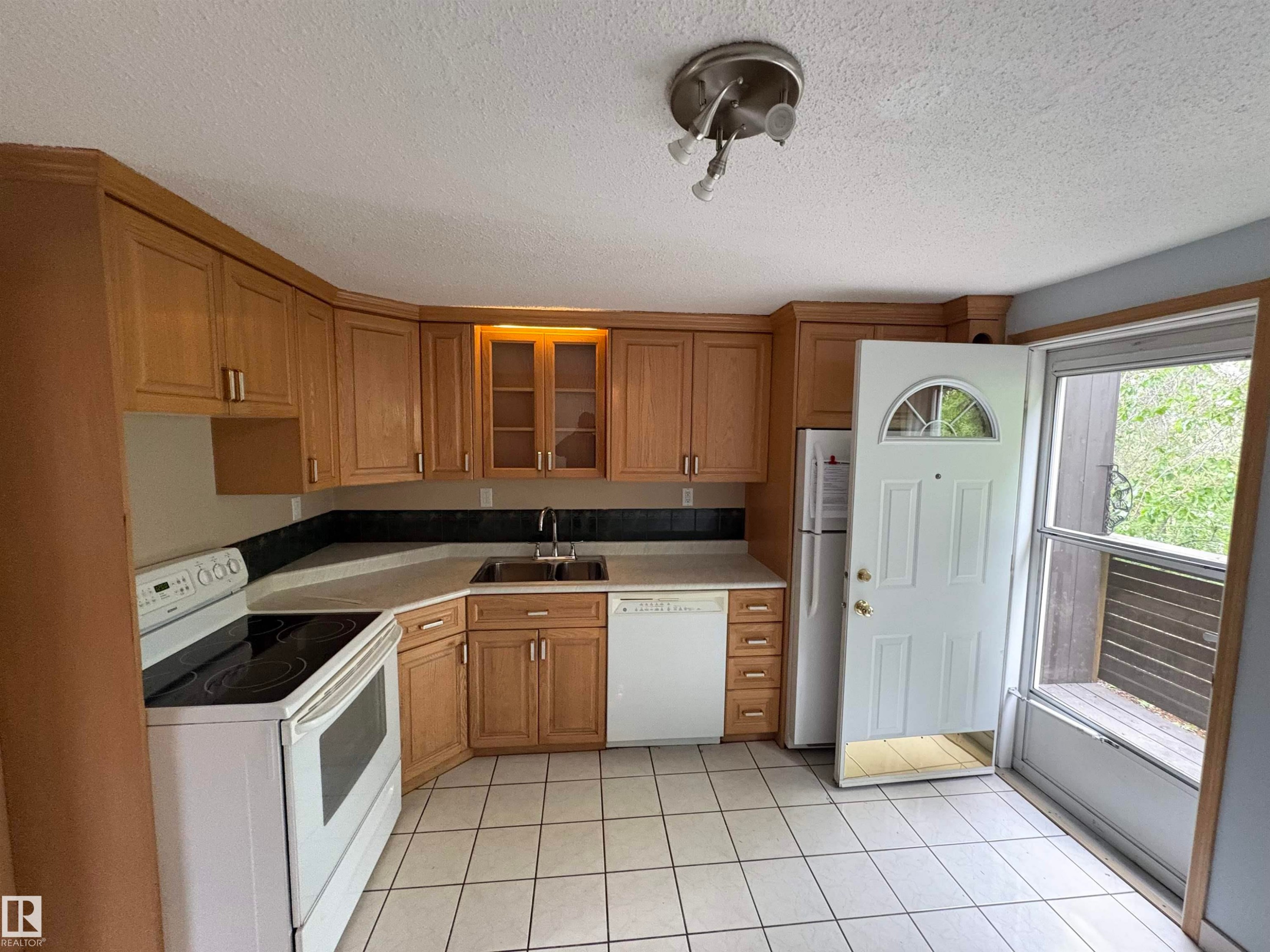 Kitchen featuring tile flooring, light wood-finish cabinetry with some glass-front doors, white appliances, and a built-in sink - 167 Ridgewood, St. Albert, AB - Indoor Photo Showing Kitchen
