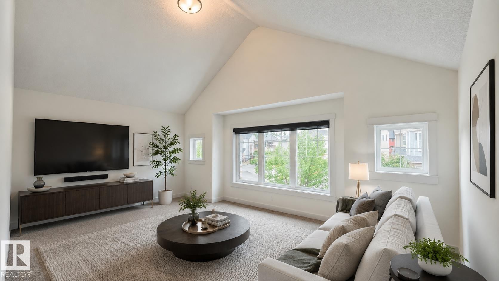 Vaulted ceiling living space featuring a large picture window, additional side windows, recessed lighting, and soft neutral carpeting - 3962 Claxton Loop, Edmonton, AB - Indoor Photo Showing Living Room