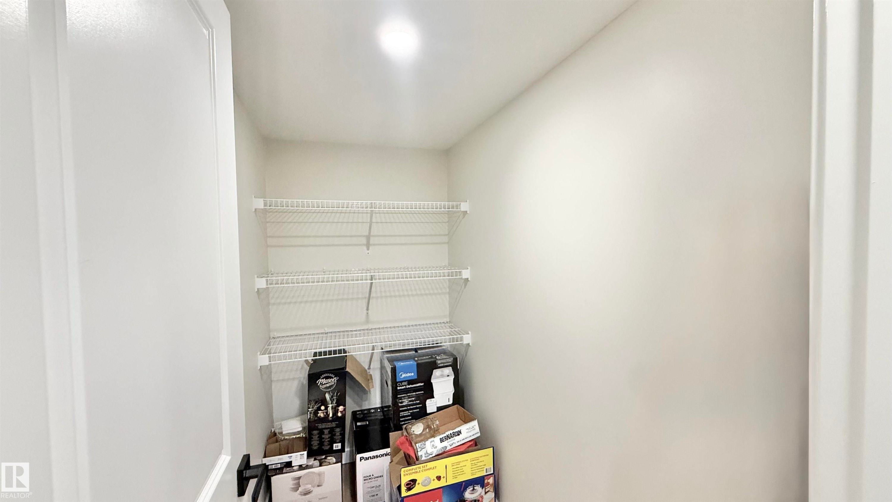 Recessed lighting illuminates an interior closet space featuring multiple wire shelving units - 3962 Claxton Loop, Edmonton, AB - Indoor