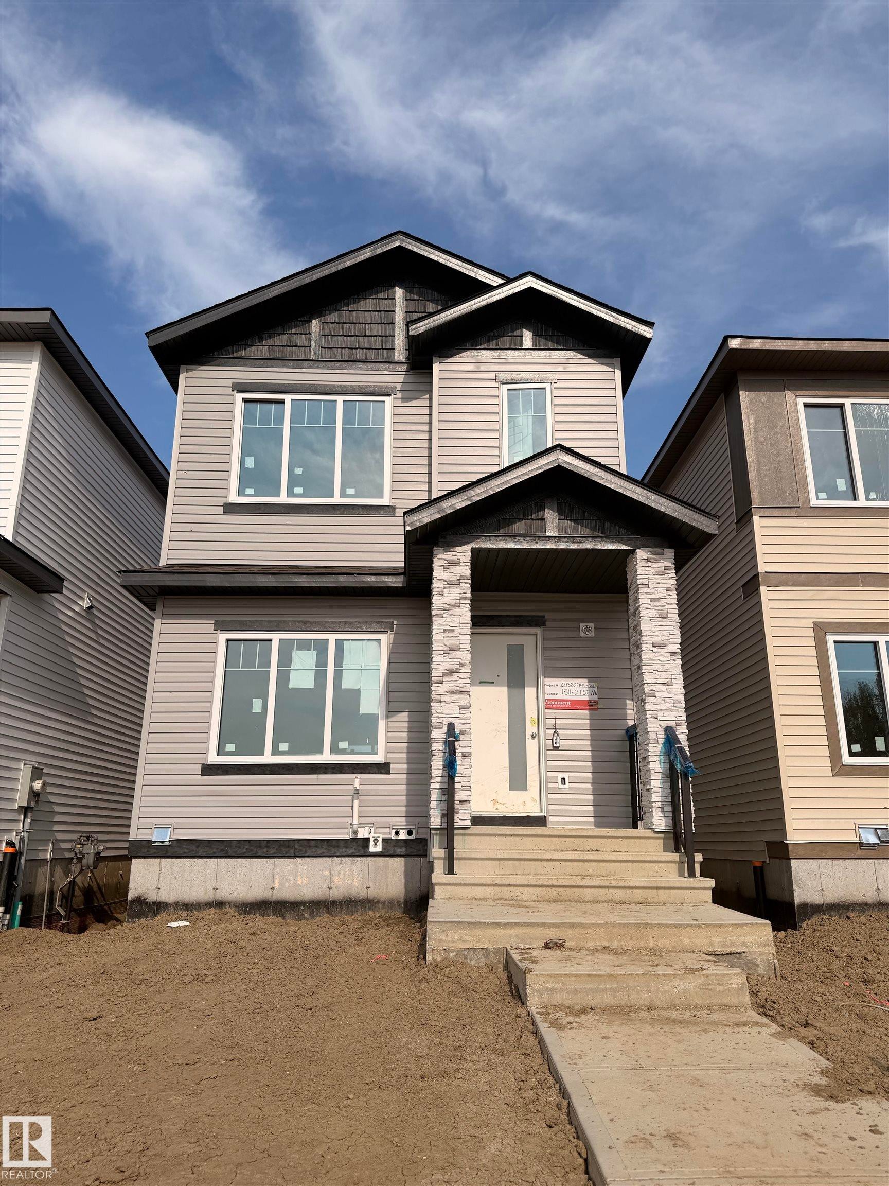Two-story residence featuring light gray siding with dark gray shingle accents - 1511 211 Street Nw, Edmonton, AB